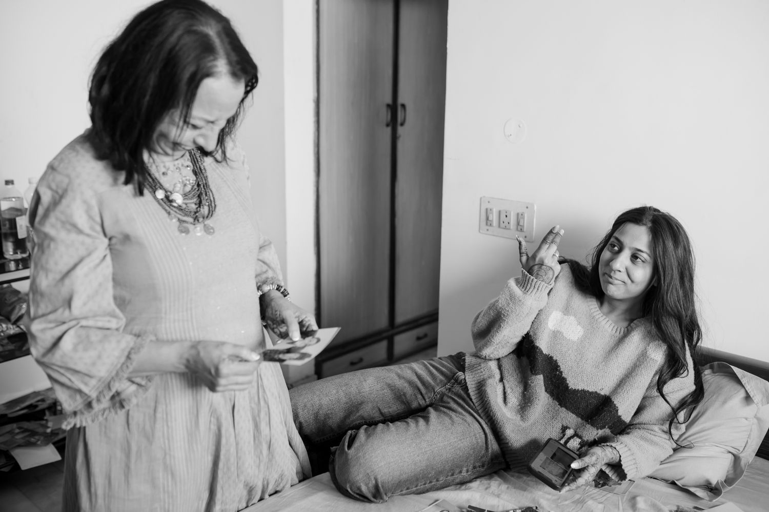 Emotional mother-daughter moment with vintage family photographs on the wedding morning by Storytelling wedding photography