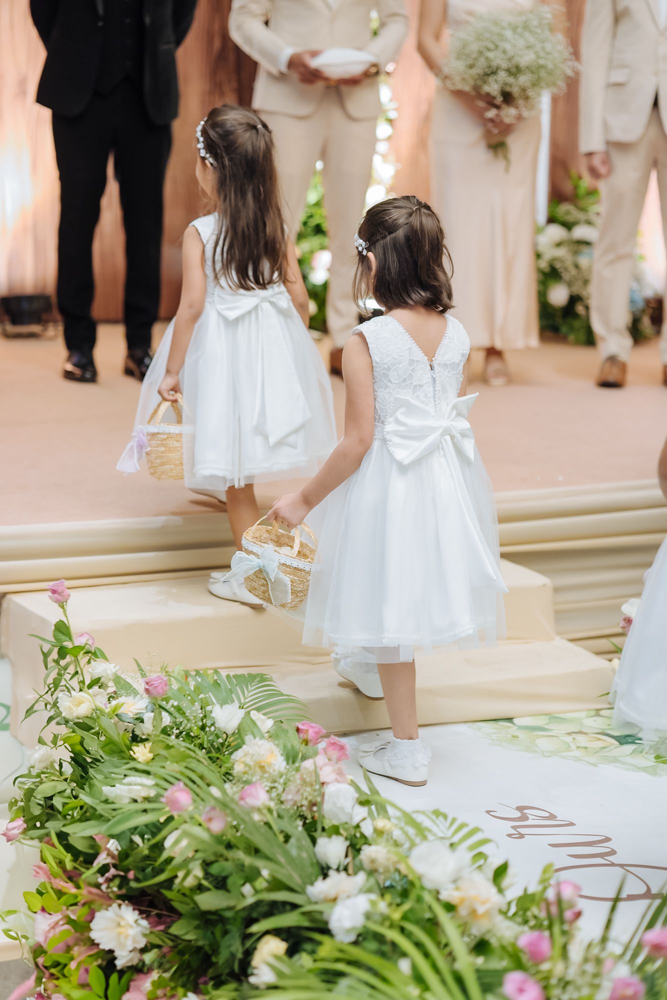 Flowergirls walking down the aisle during Shorye and Leah's Christian wedding ceremony at Tivoli Chattarpur