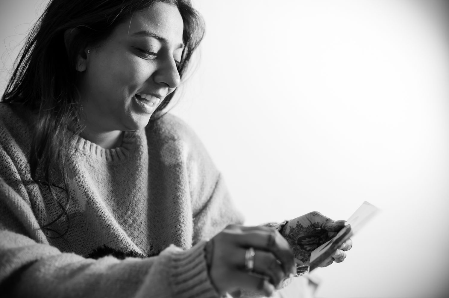 Bride Itisha looking through old family photographs on the morning of her Haldi ceremony by Storytelling wedding photography