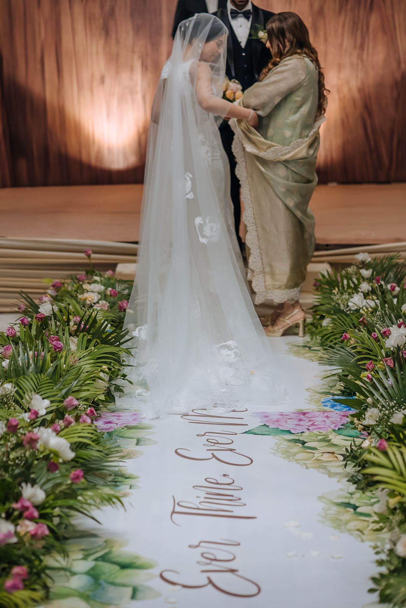 Leah walking down the aisle with her mother during her Christian wedding ceremony at Tivoli Chattarpur