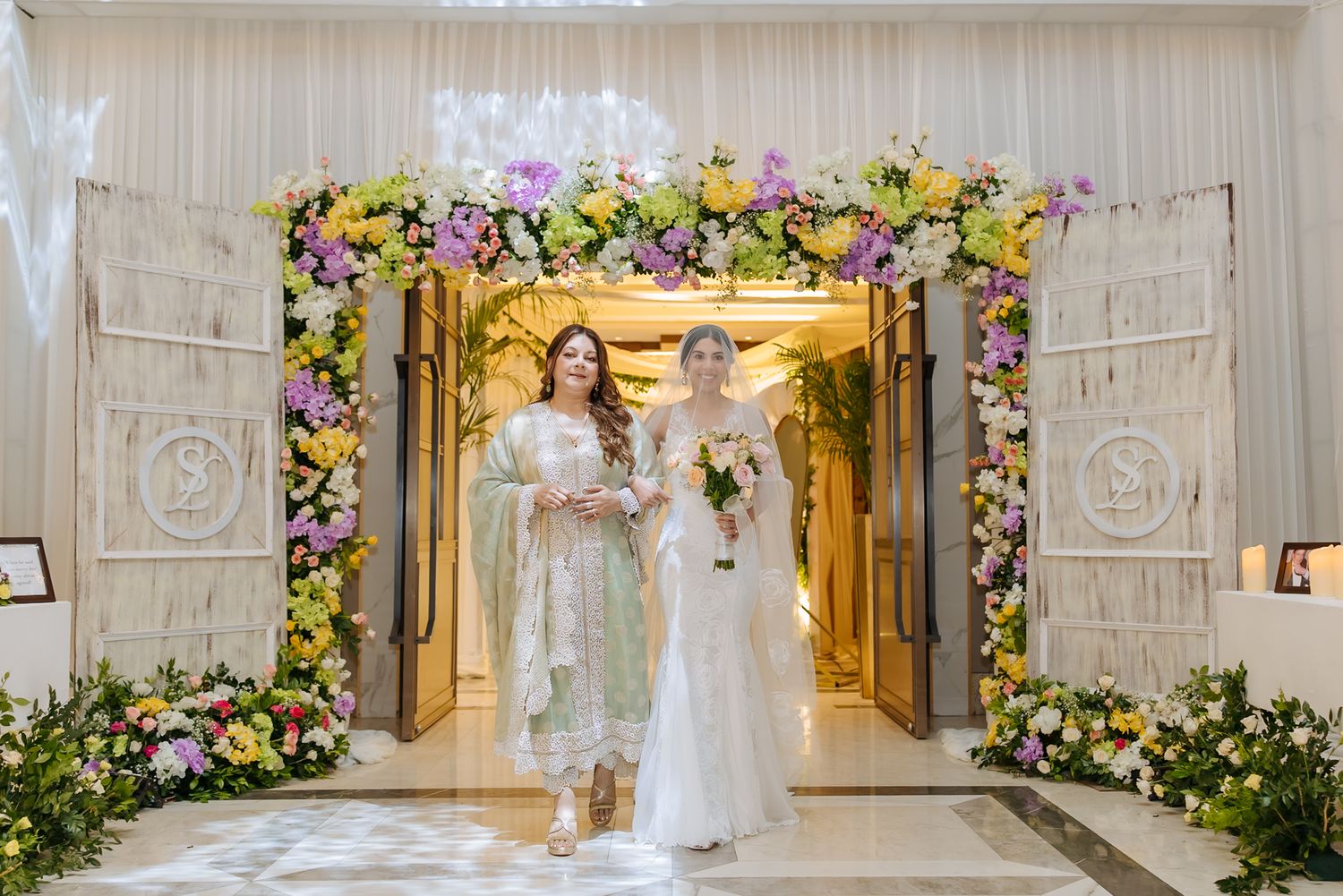 Leah walking down the aisle with her mother during her Christian wedding ceremony at Tivoli Chattarpur