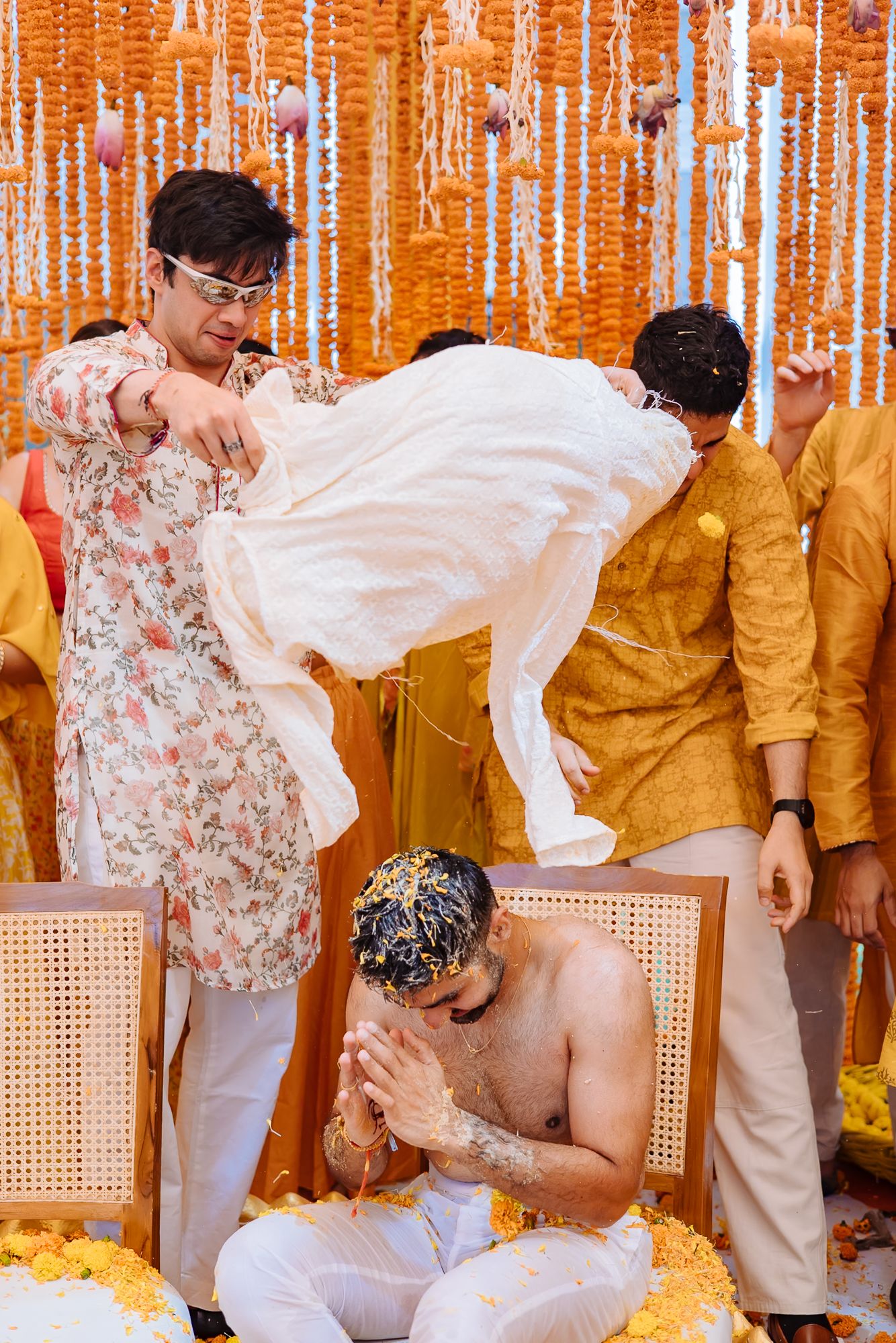 Shorye surrounded by family as they pull apart his kurta during the Haldi at Tivoli Chattarpur