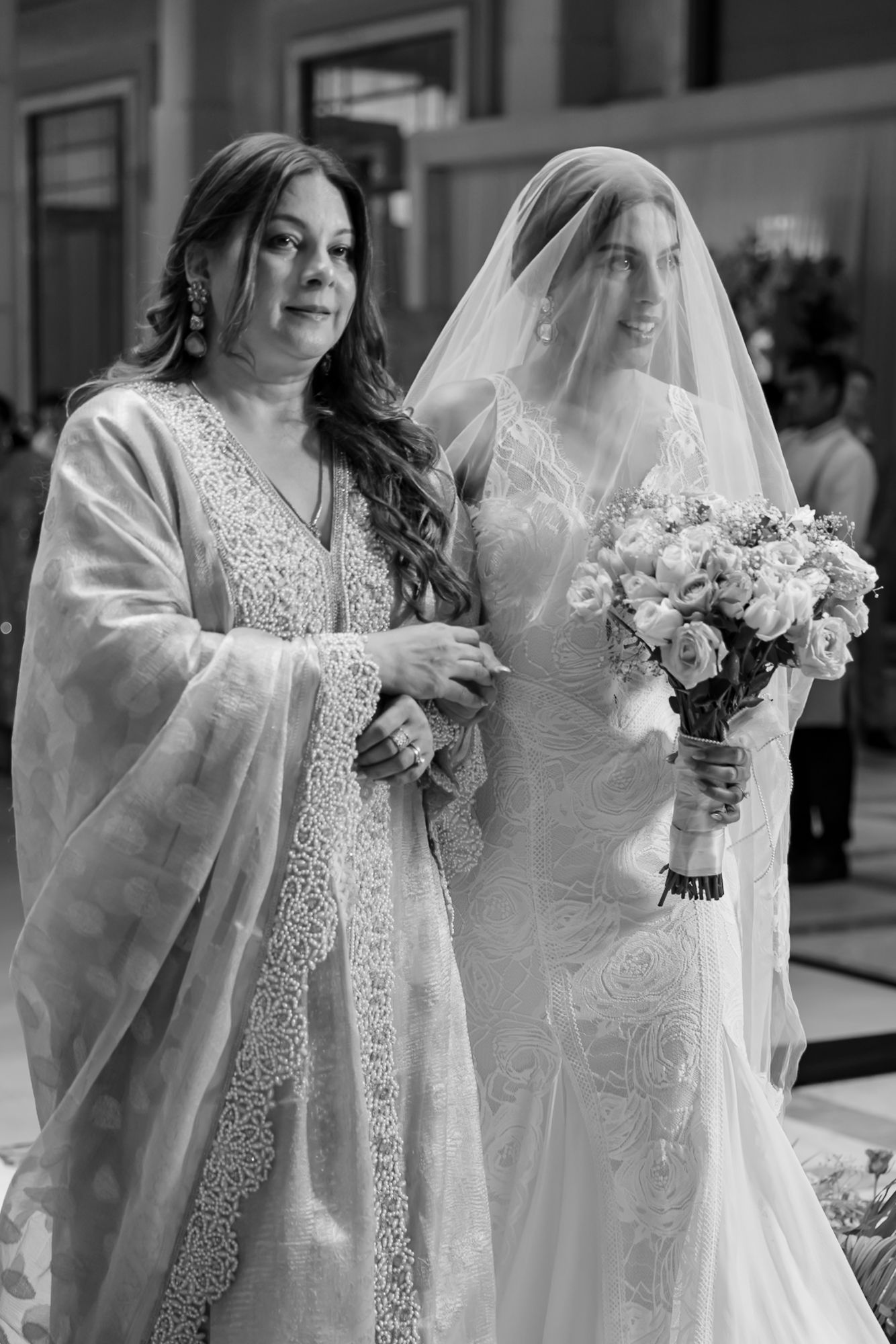 Leah walking down the aisle with her mother during her Christian wedding ceremony at Tivoli Chattarpur