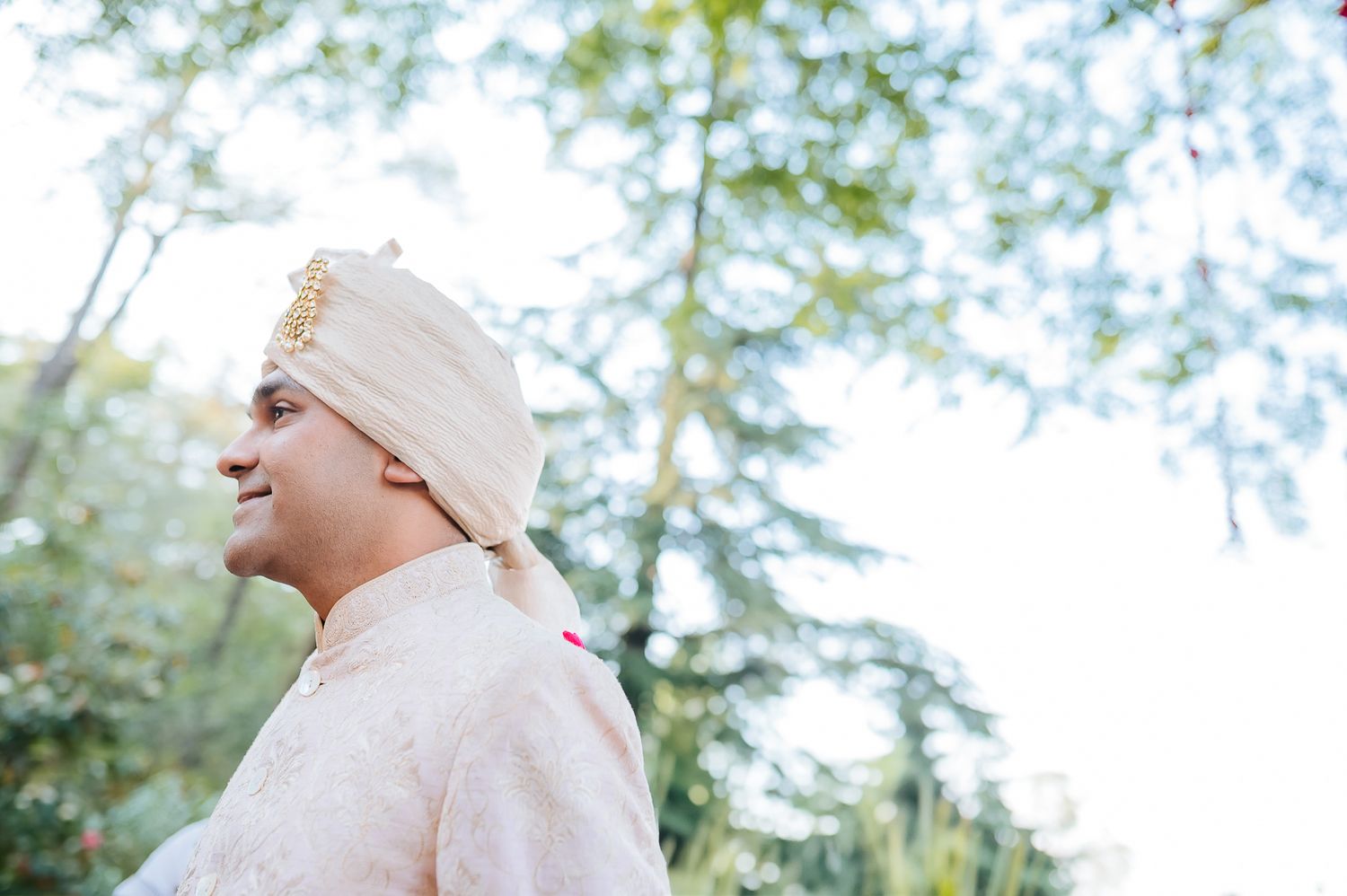 Groom reaction to an Indian bride in maroon lehenga entering with her family at an intimate wedding of 30 people in the hills in Kasauli.
