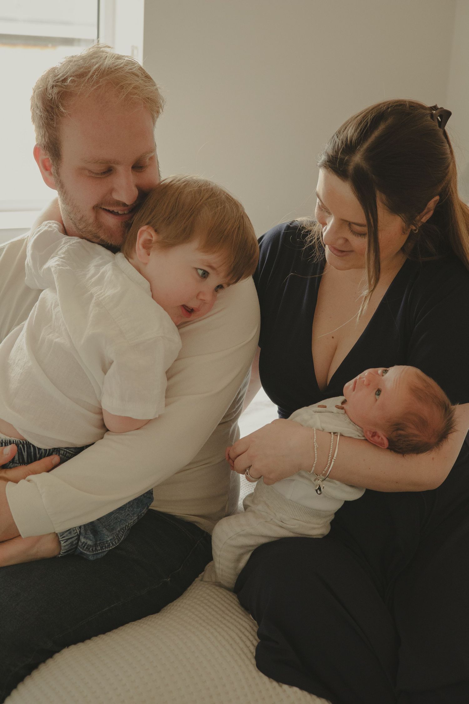 A family of four during photoshoot, having cuddles.