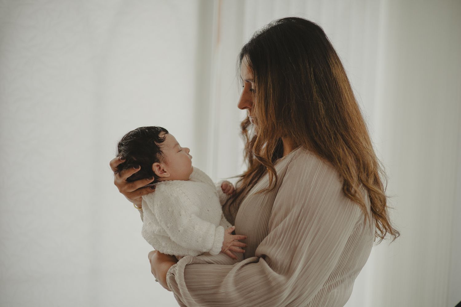 Mum looking down at baby during newborn shoot in Telford, Shropshire.