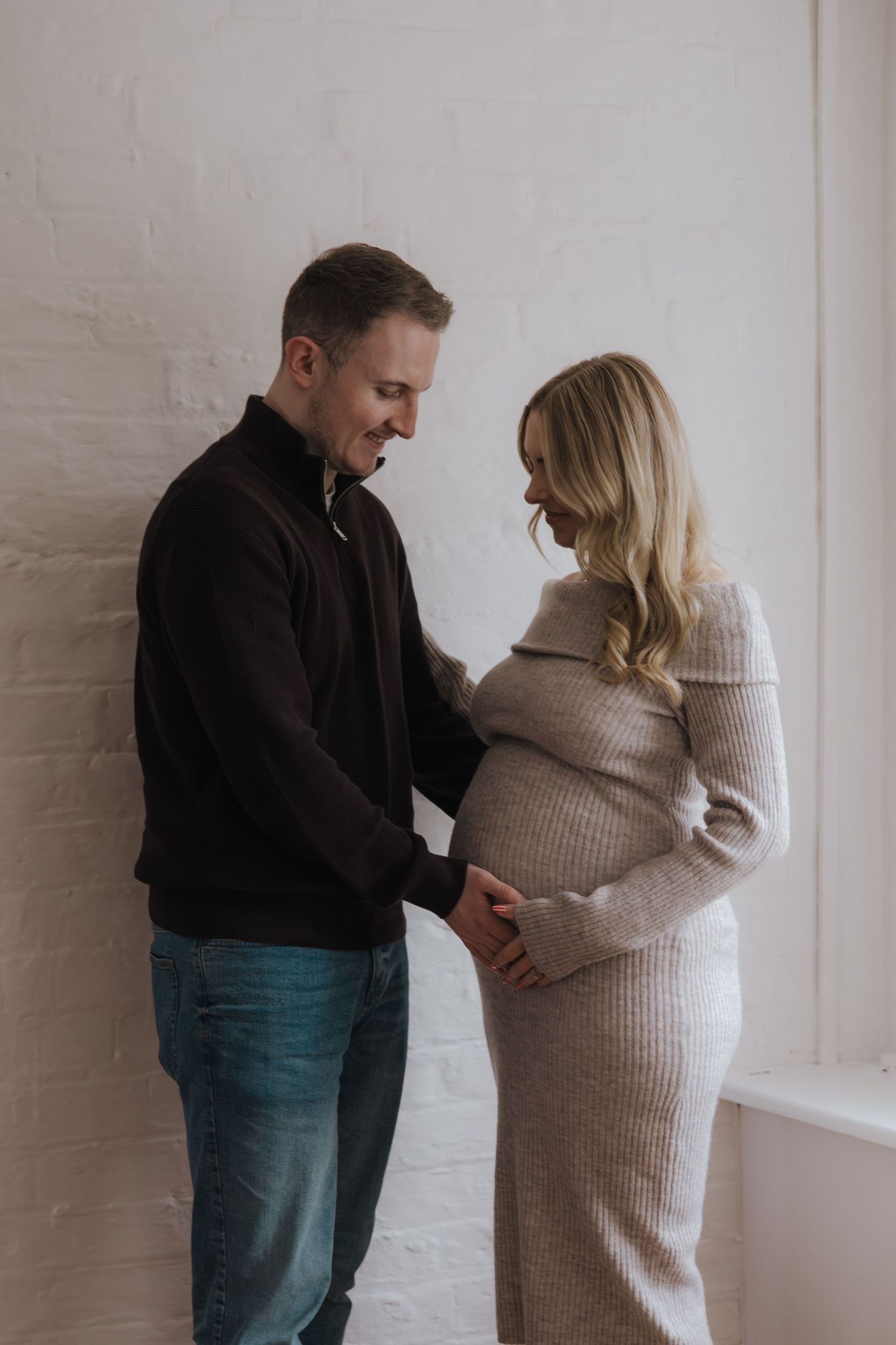 Mum and dad waiting their baby in studio in Telford.