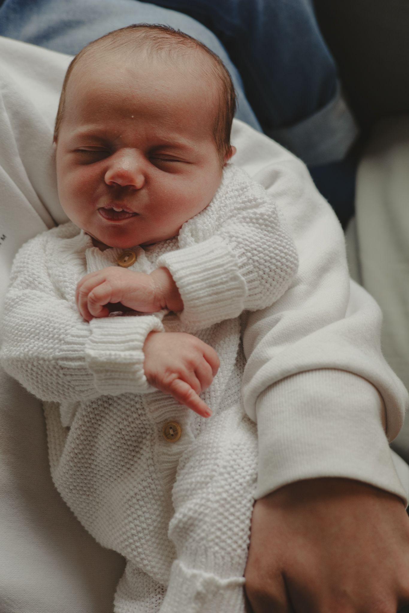 A newborn baby asleep in brothers arms during a newborn shoot in Telford, Shropshire.