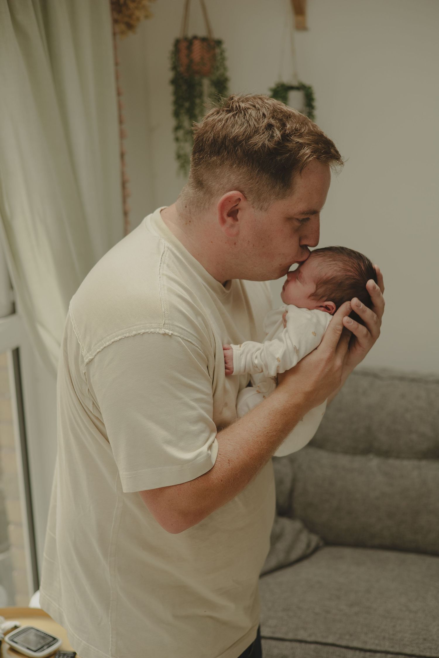 Dad kissing babies head during newborn photoshoot in Telford.