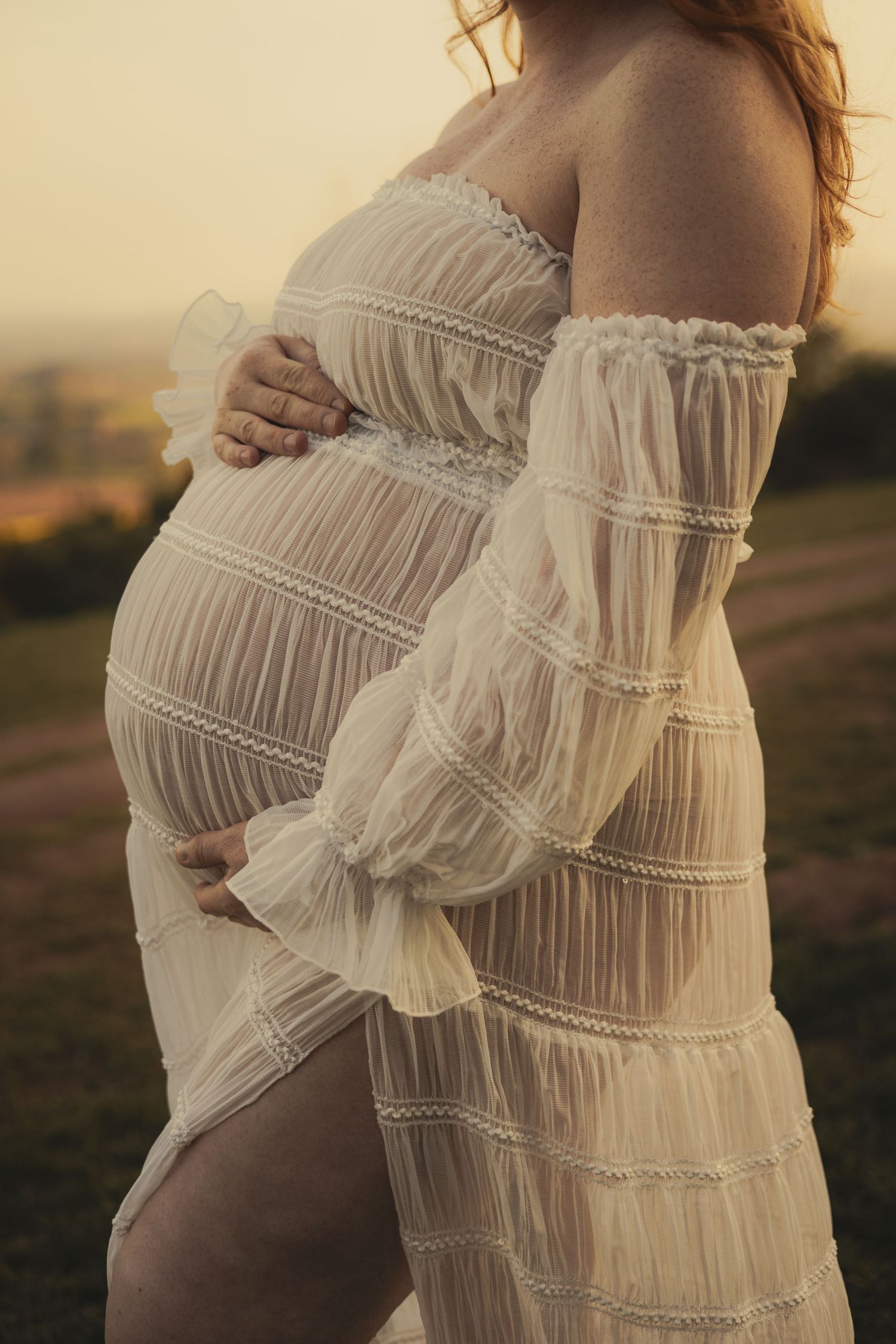 A mother holding her bump during a family sunset shoot in Shrewsbury, Shropshire