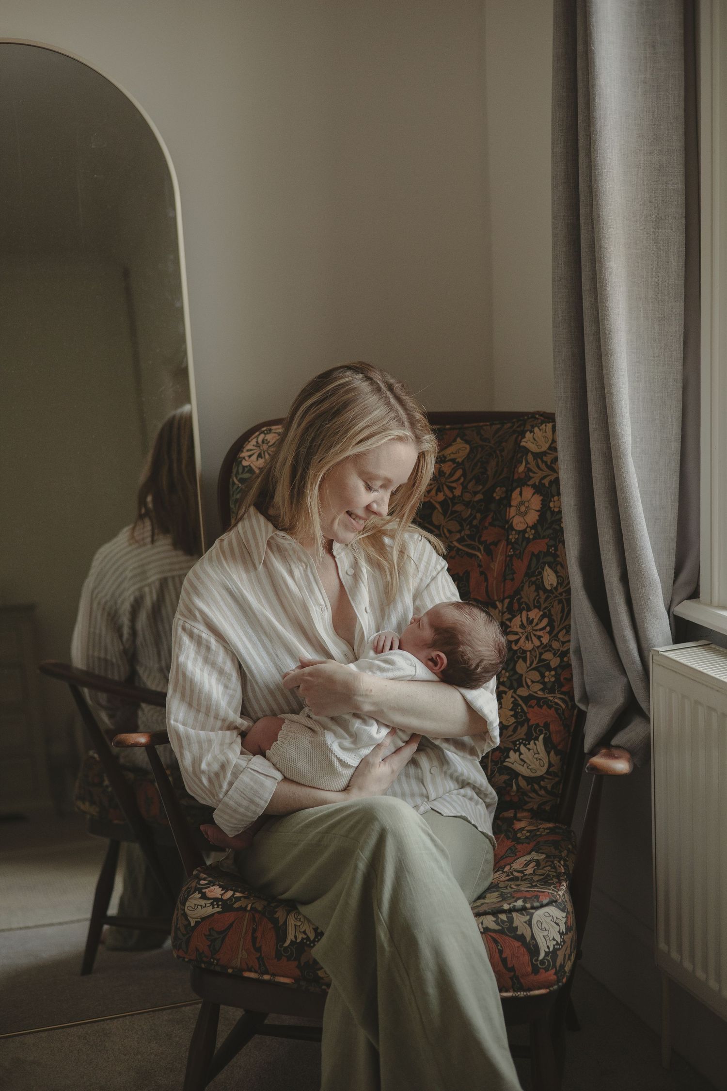 Baby girl and mother sat down during home photoshoot in Shrewsbury.