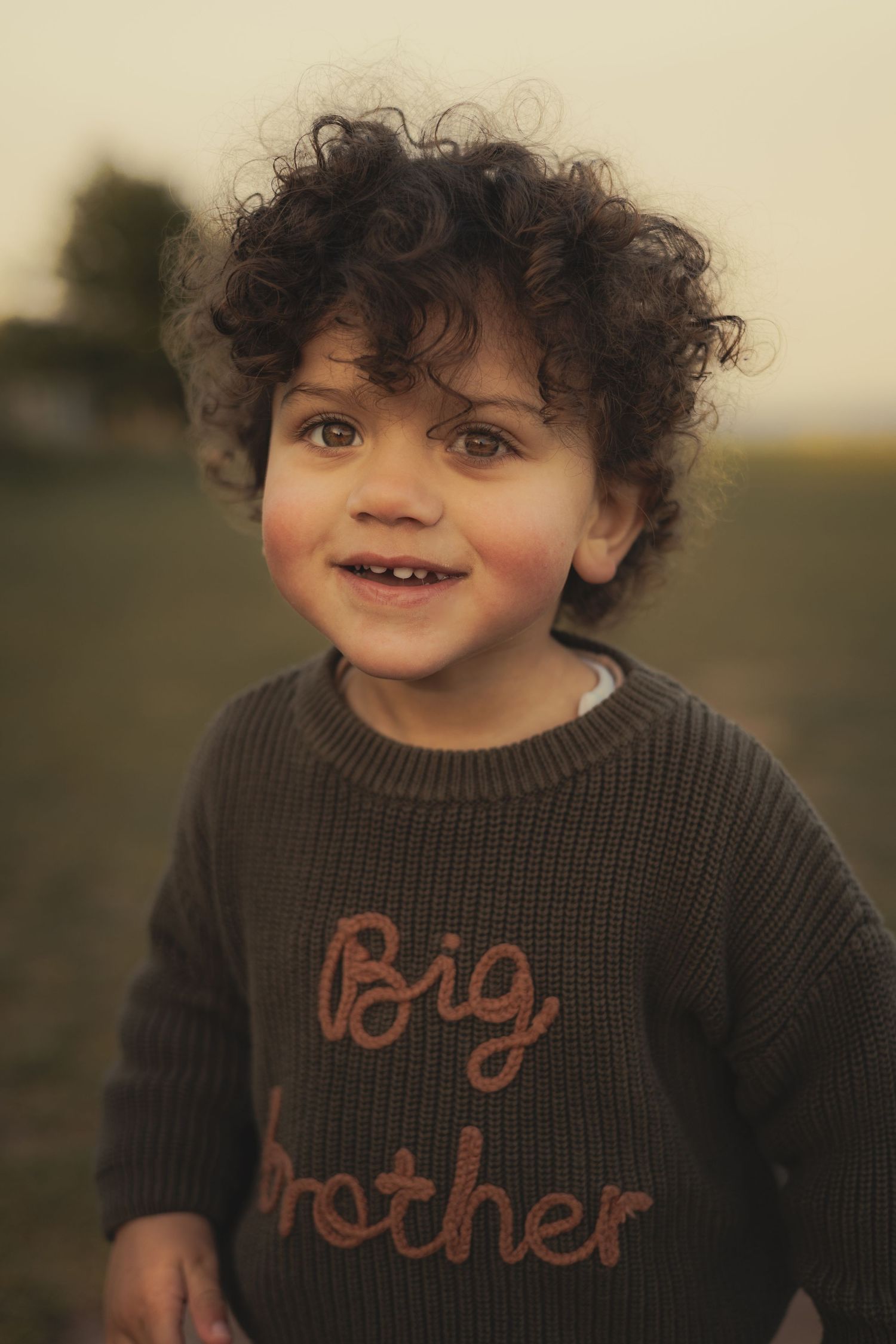 Toddler smiling at camera during family photoshoot.