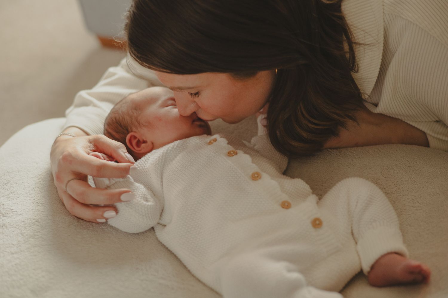 Mum kissing baby during newborn photoshoot in Telford.