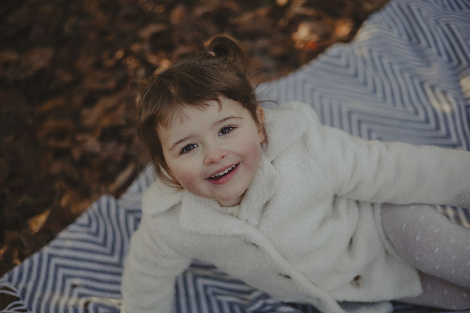 Little girl looking up at camera during photoshoot in Telford, Shropshire.