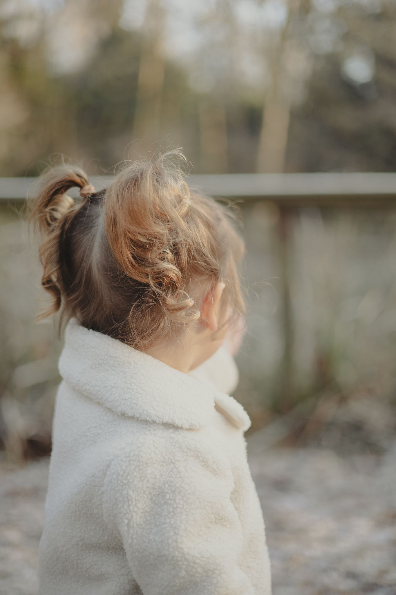 Curly haired girl during outdoor family photoshoot.