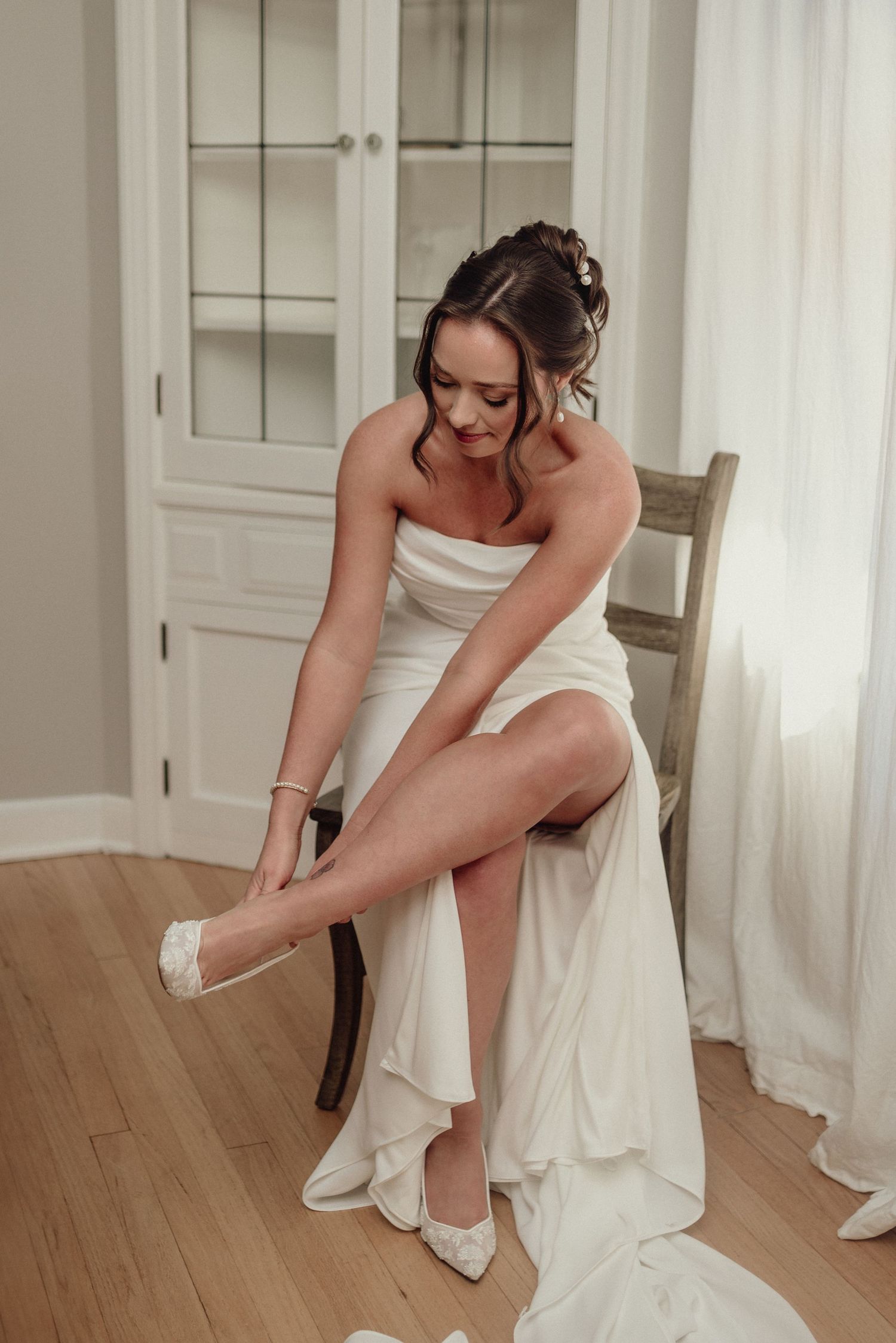 Getting ready scene showing wedding dress and shoes being put on.