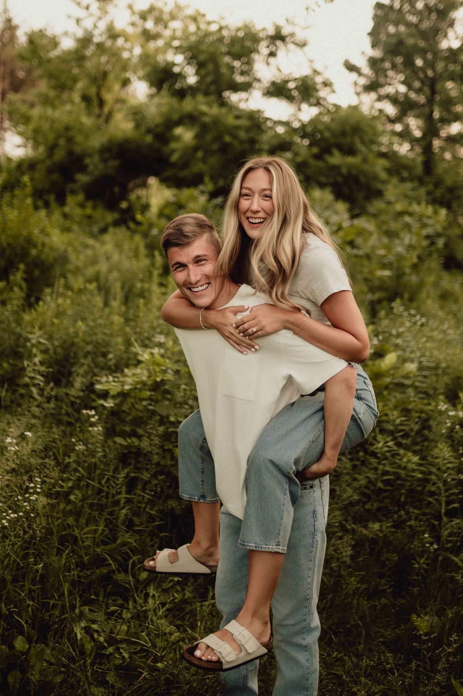 Playful piggyback ride captured in a lush green outdoor setting.