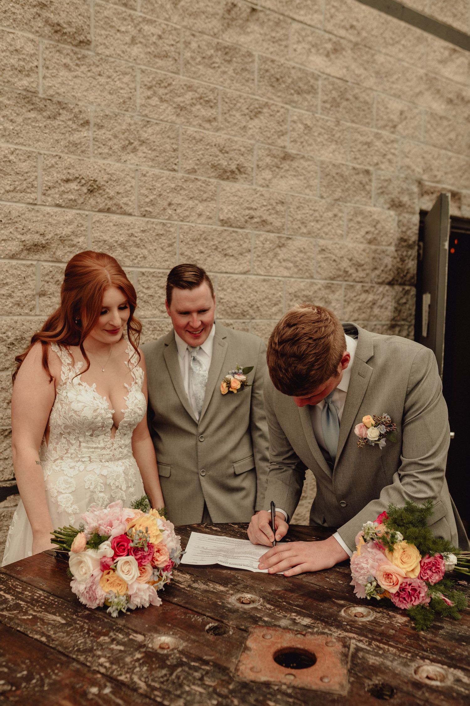 Wedding couple and witnesses sign marriage documents on rustic wooden surface in sequence of progressive shots.