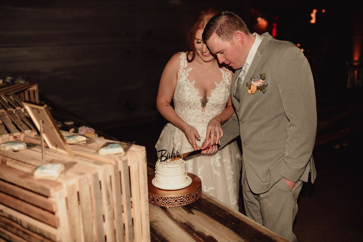 A couple signs their wedding paperwork at a rustic wooden table during their ceremony.