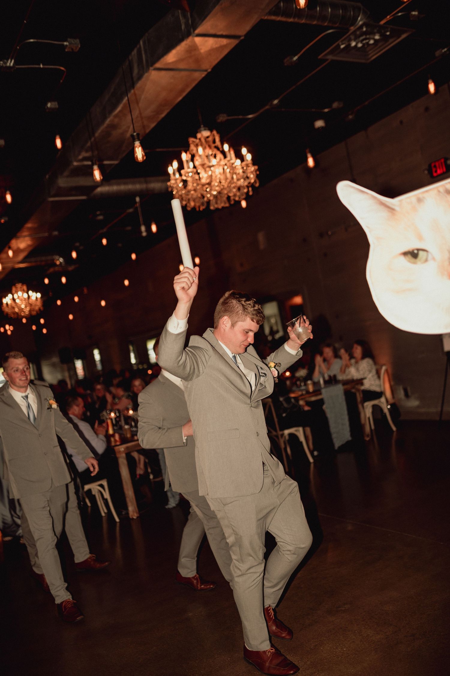 A sequence of dance moves showing someone in gray attire spinning and twirling on a dimly lit dance floor.