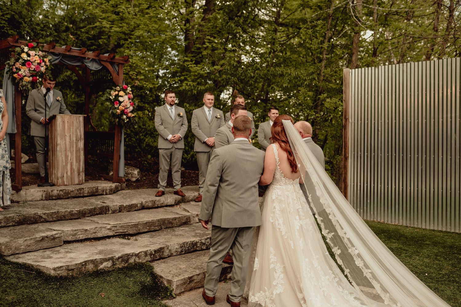 Wedding couple walks up stone steps in an outdoor garden setting during their special celebration.