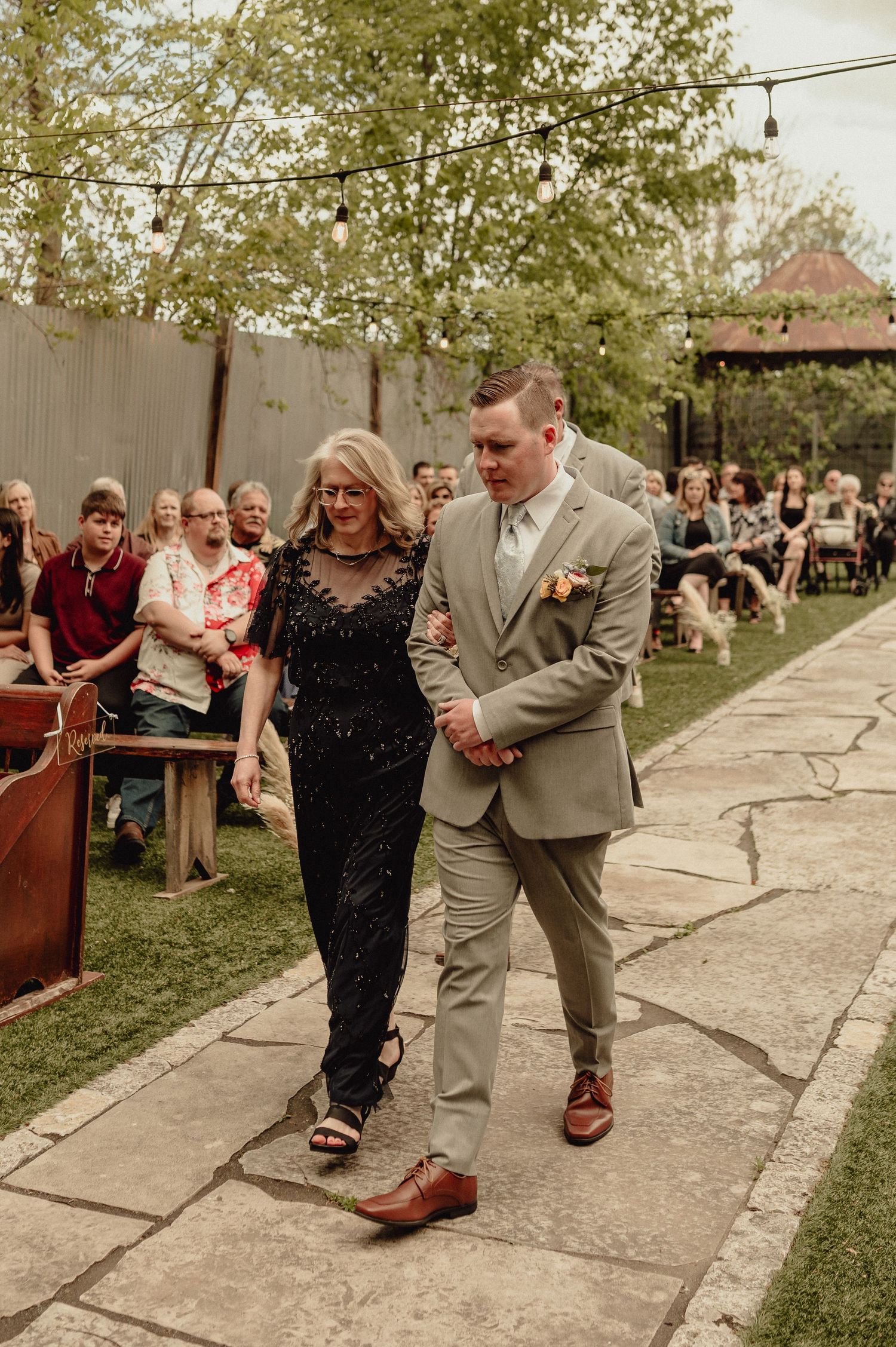 Couple dancing together at an outdoor wedding reception, with guests watching in the background.
