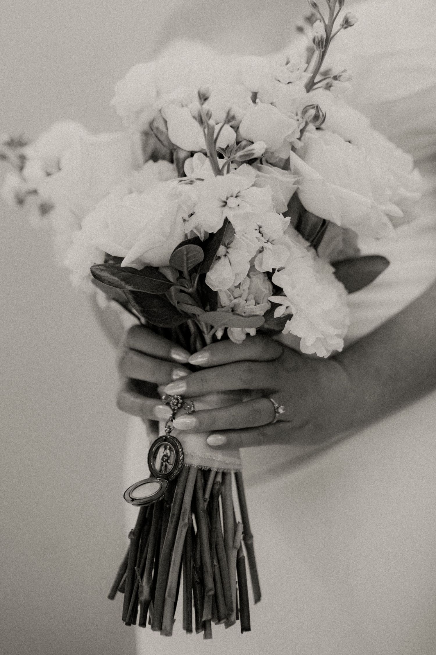 A black and white image series showing hands holding a white floral bouquet with cascading ribbons.