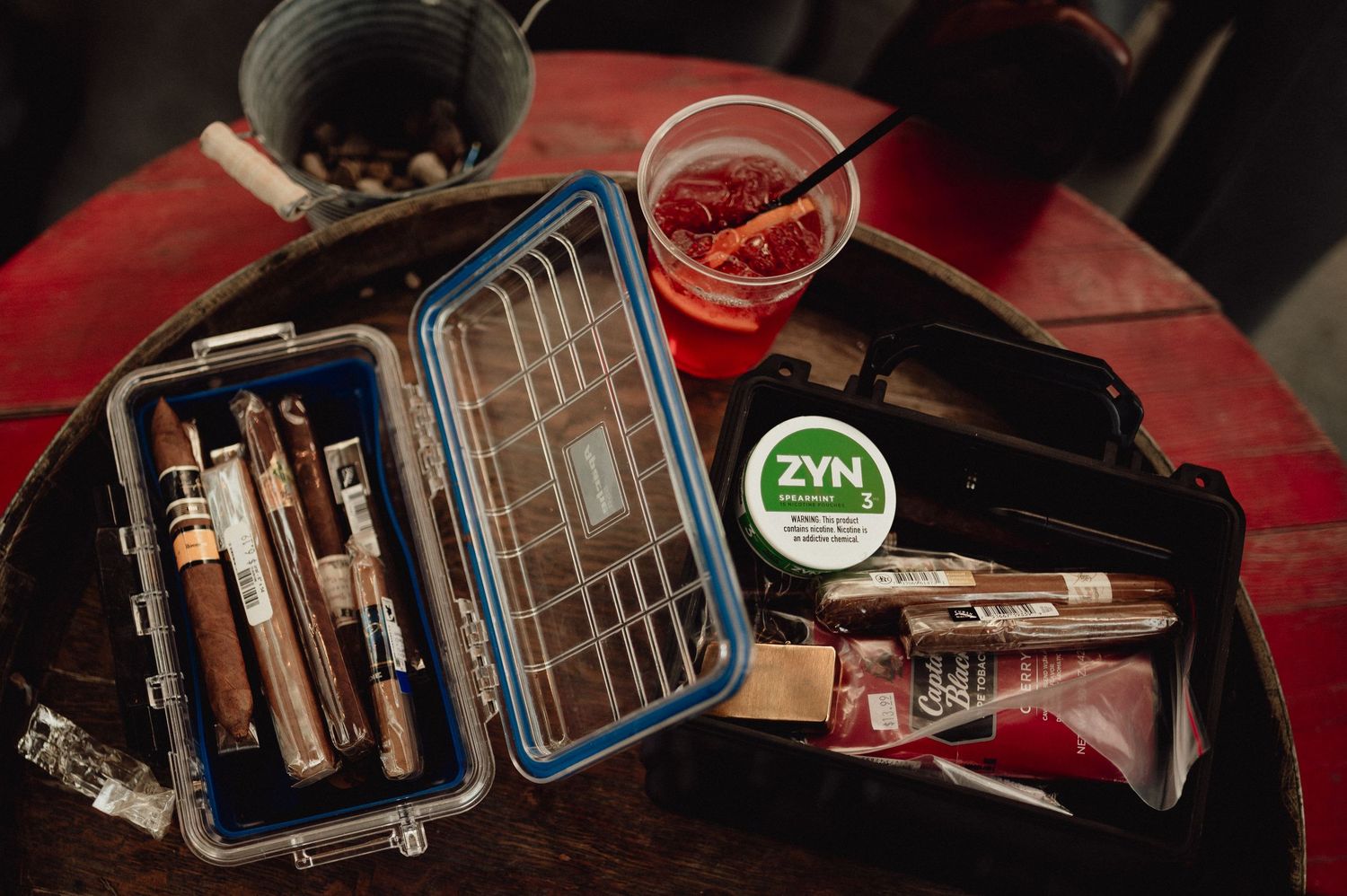 Vintage sewing machine supplies and tools including thread spools, scissors, and measuring tape laid out on a wooden surface.