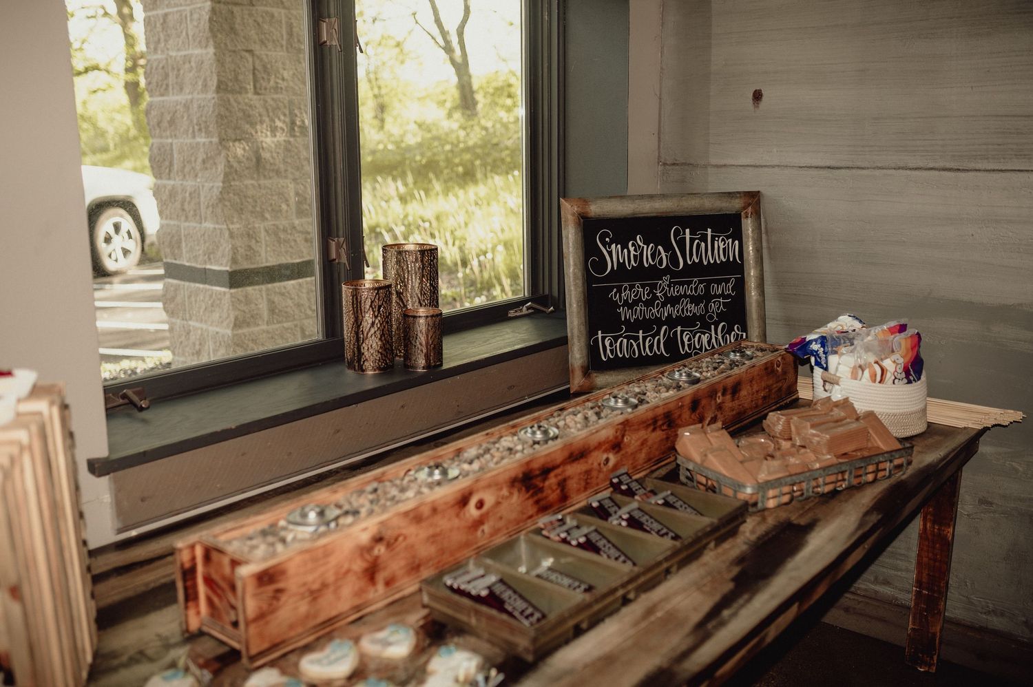 Rustic wooden serving station with vintage decor and chalkboard sign displayed near a window in natural light.