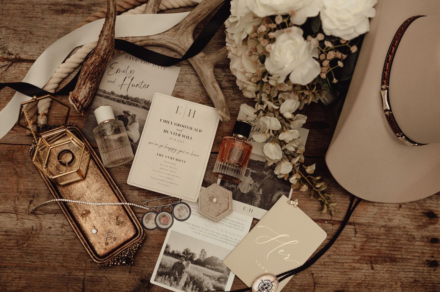 Wedding details including rings, invitations and decorative elements on rustic wooden surface.