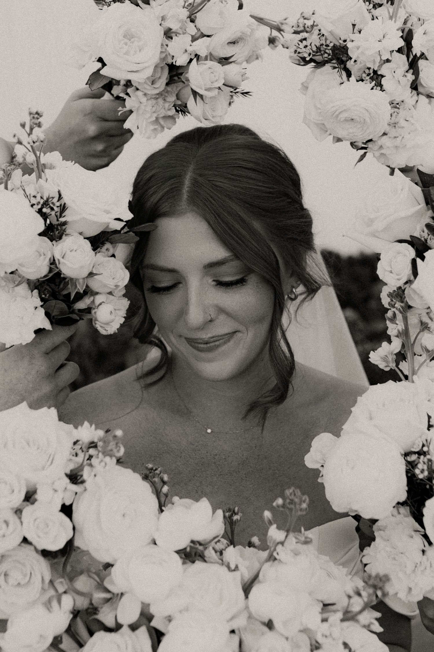 A black and white photo series shows a person surrounded by delicate white flowers in a dreamy, romantic composition.