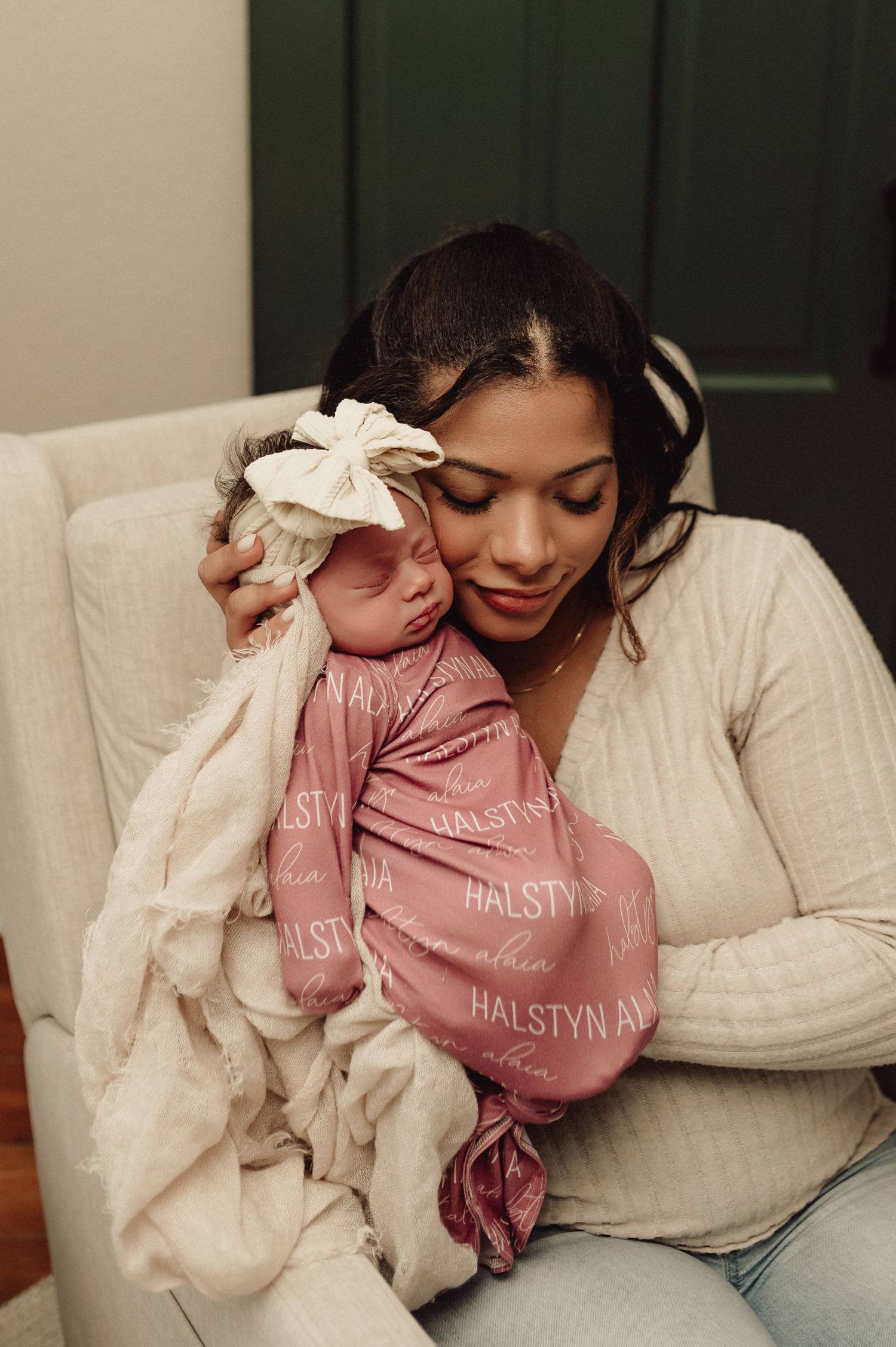 A tender moment captured between parent and baby in cozy white and pink sweaters.