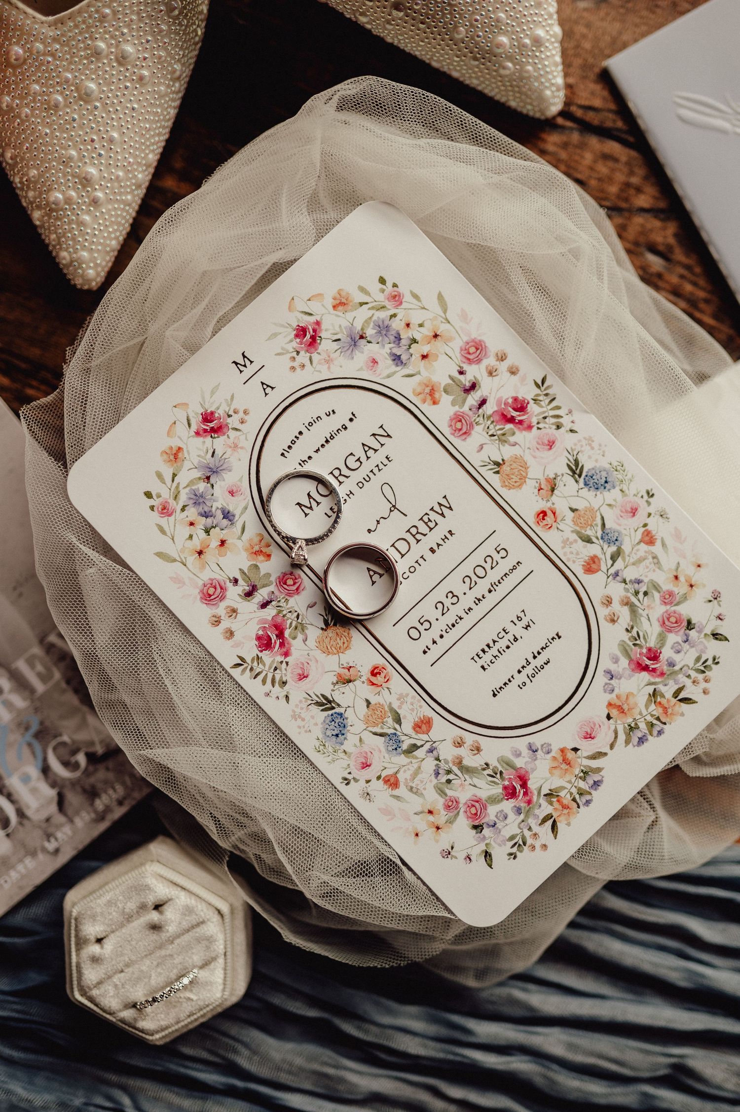 Wedding invitation cards with floral designs and delicate tulle fabric create an elegant vintage-inspired layout.