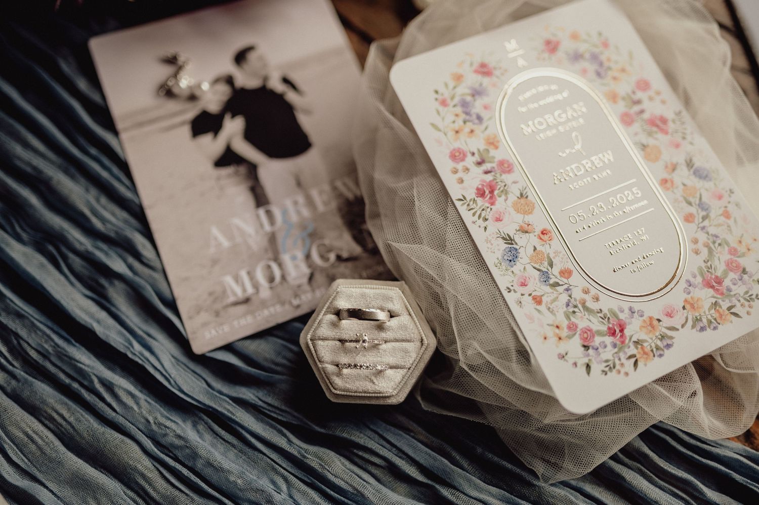Delicate wedding stationery and invitation suite featuring floral patterns and elegant typography laid out on a textured surface.