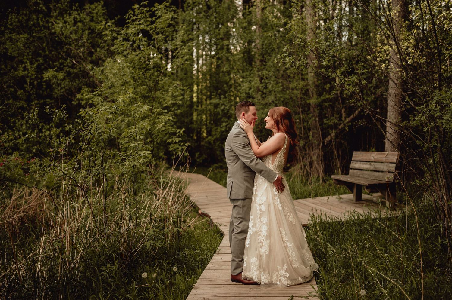 A couple shares romantic moments in a forest setting during their wedding photo session.