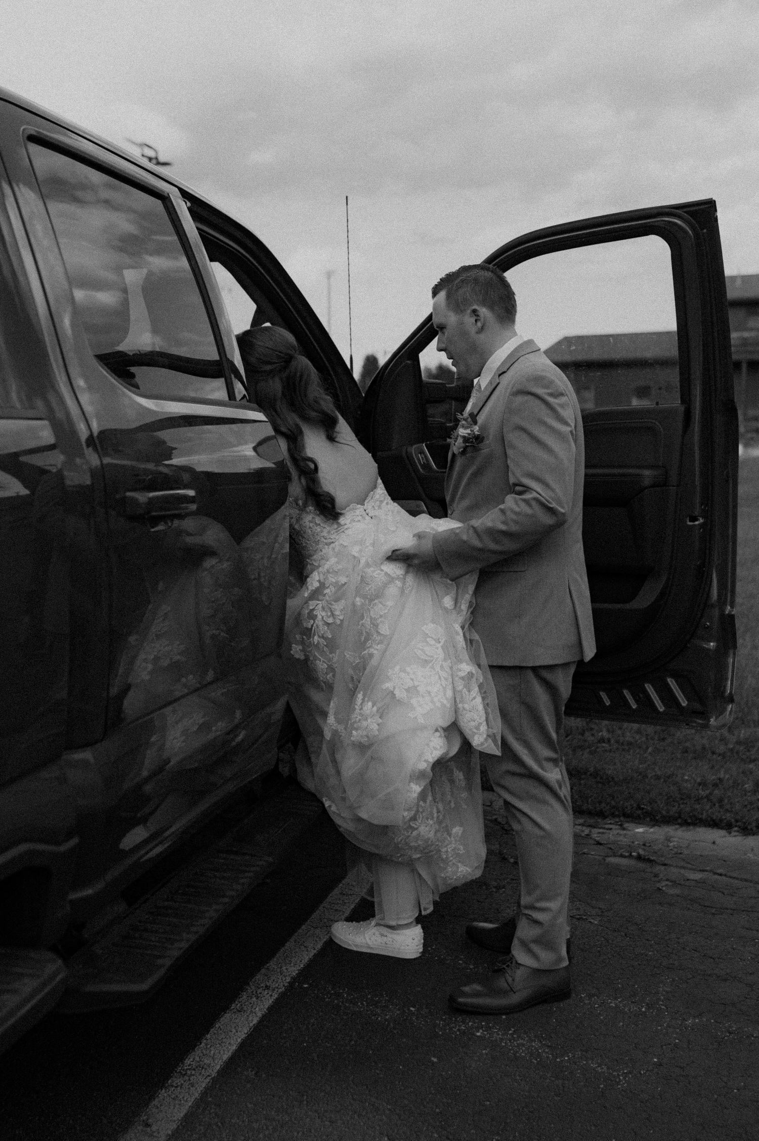 A sequence of black and white photos showing someone in a fluffy dress getting into a car.