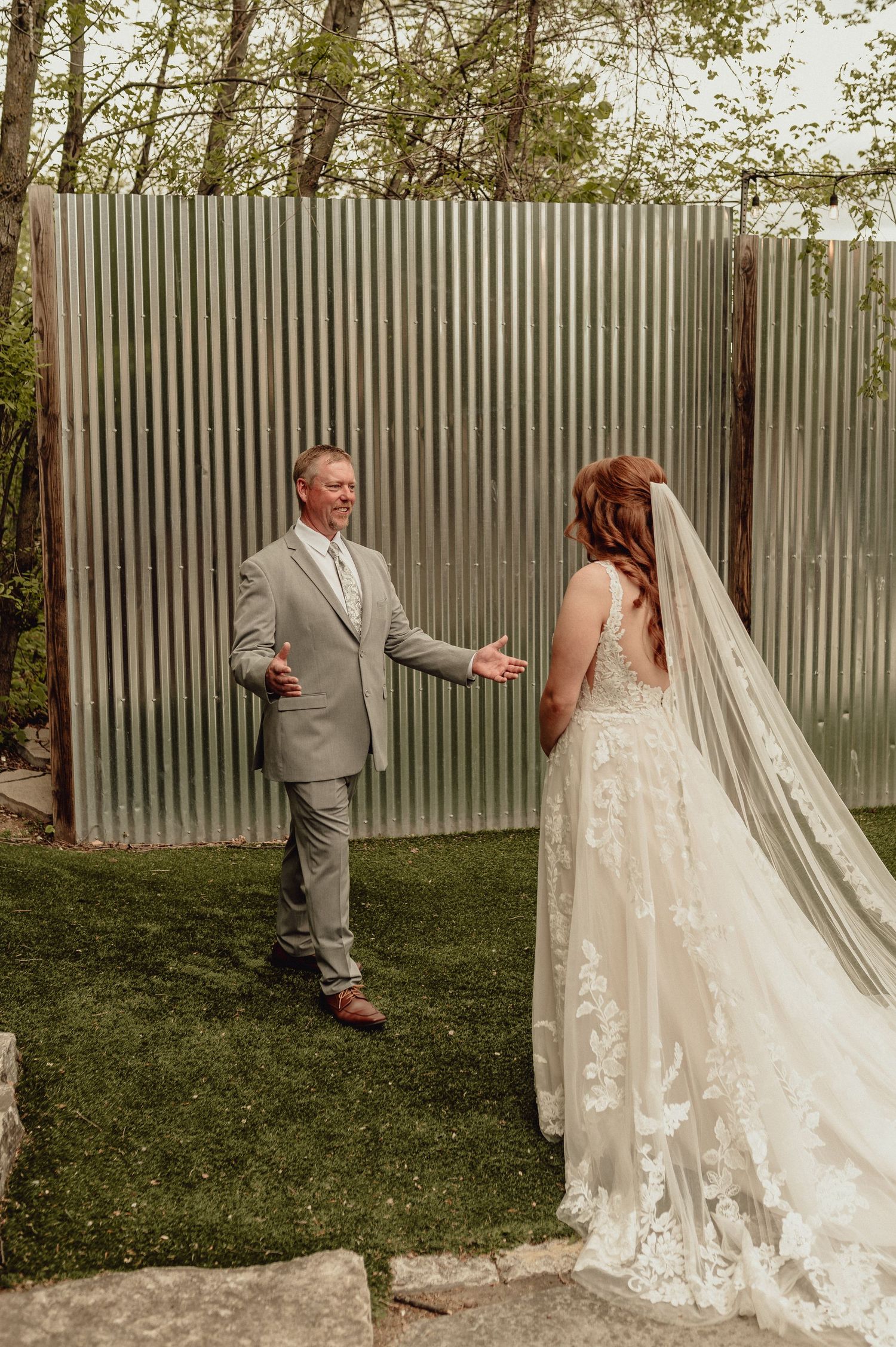 A sequence of first look wedding photos showing a couple meeting in a garden with a corrugated metal fence backdrop.
