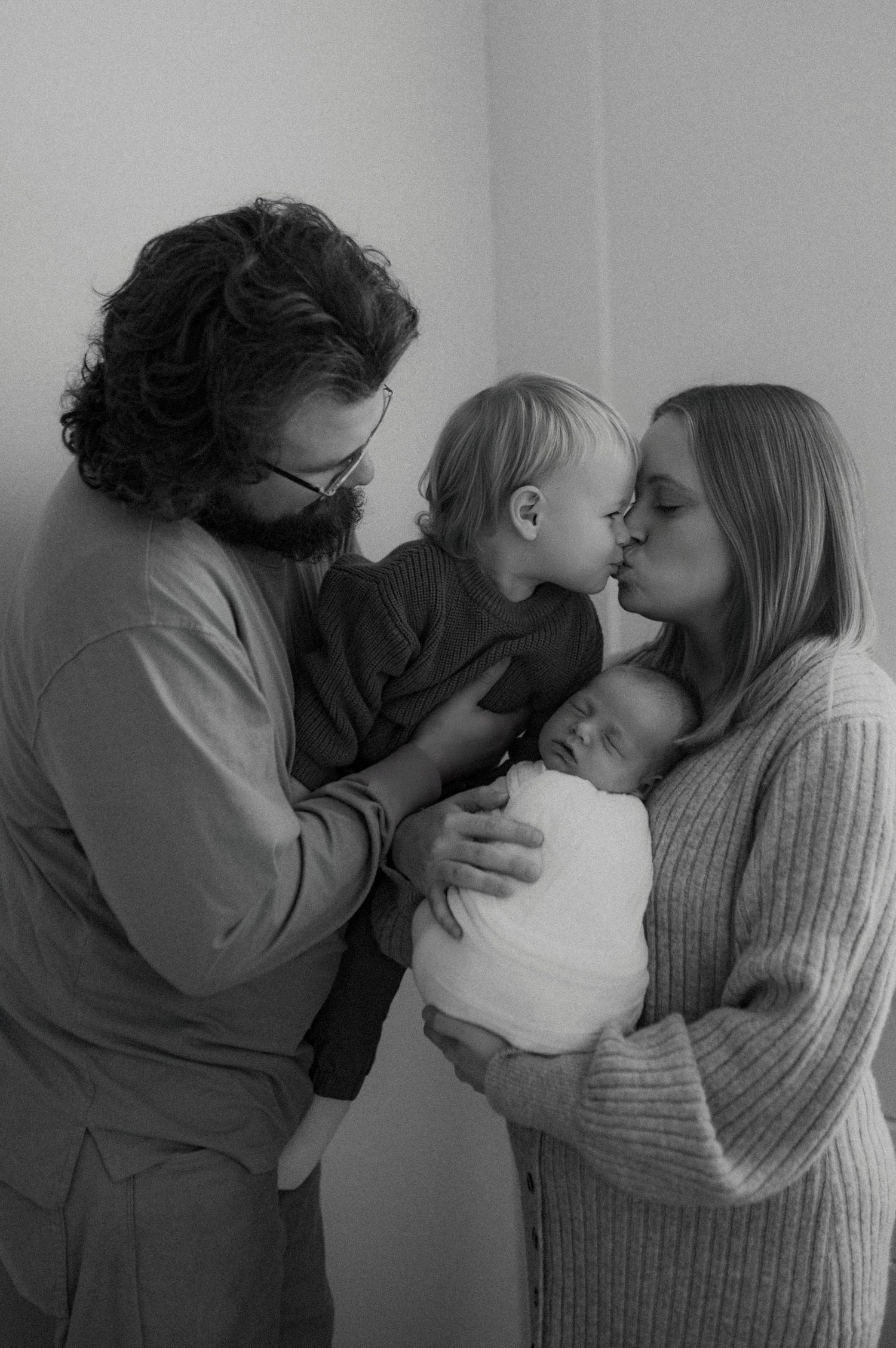A series of five black and white photographs showing a couple sharing intimate kisses in similar poses.