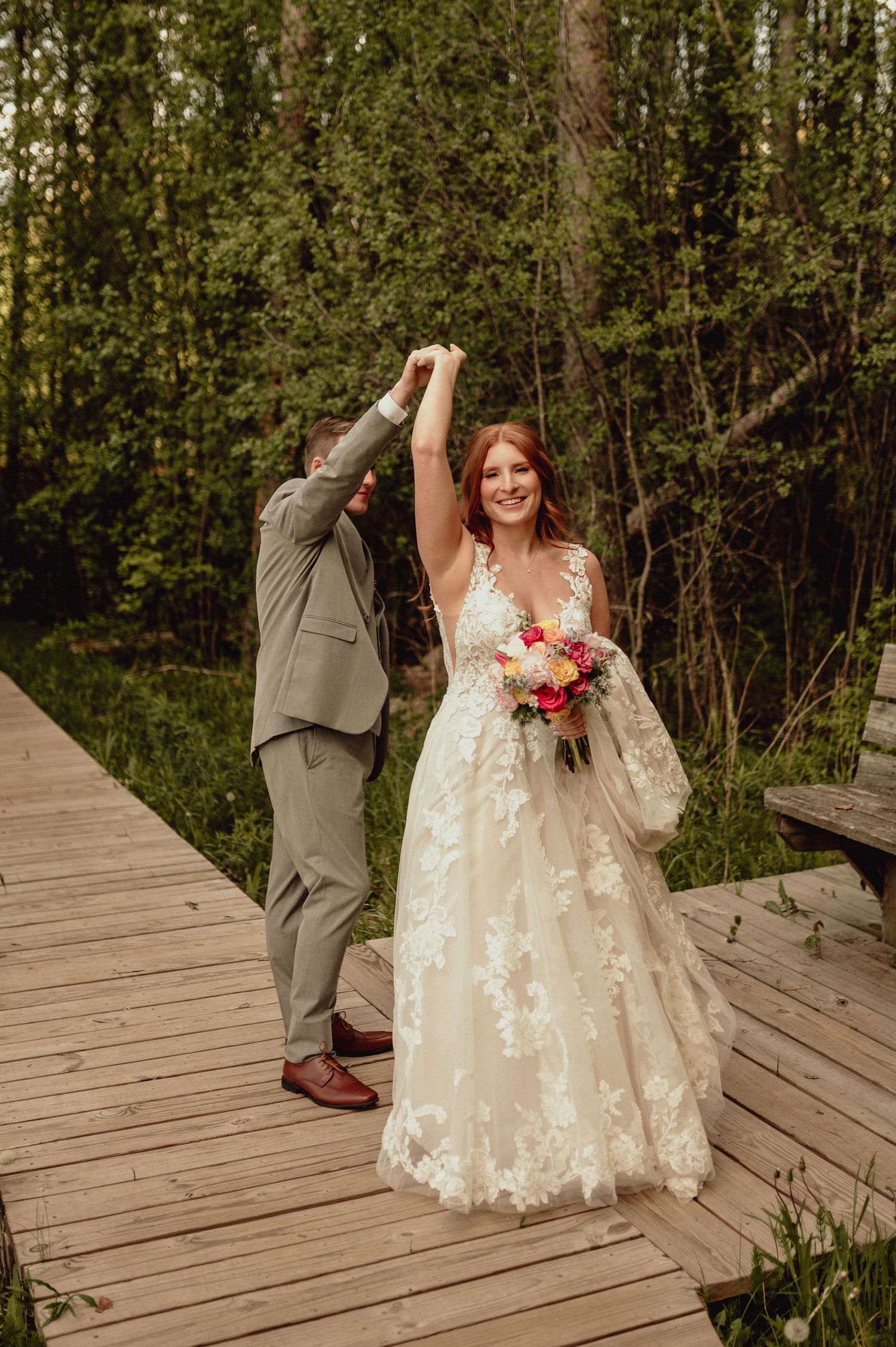 A series of four wedding photos showing playful moments on a wooden boardwalk surrounded by lush greenery.
