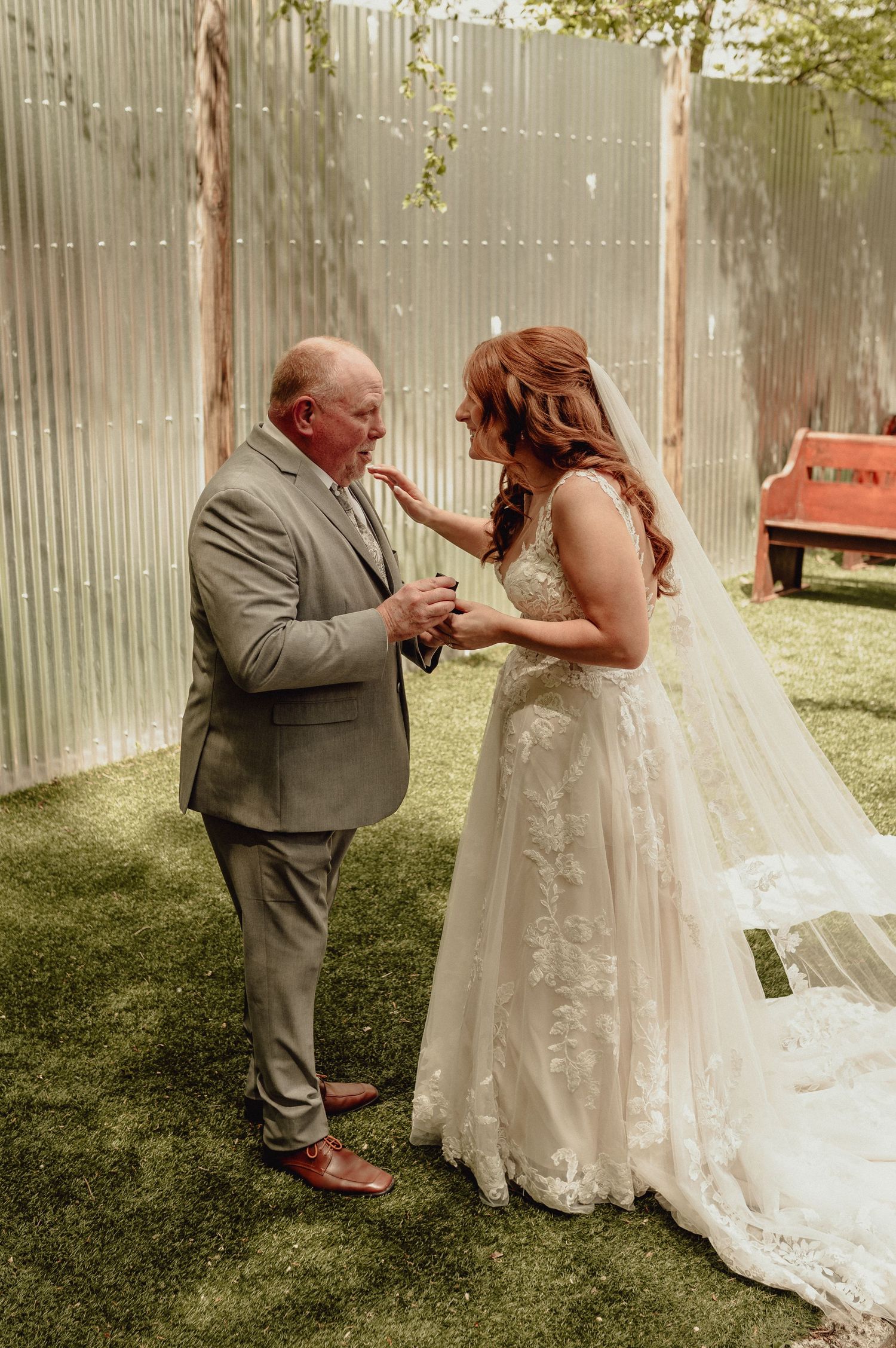 A touching sequence of a bride in a lace gown sharing a special moment with someone in a gray suit outdoors.