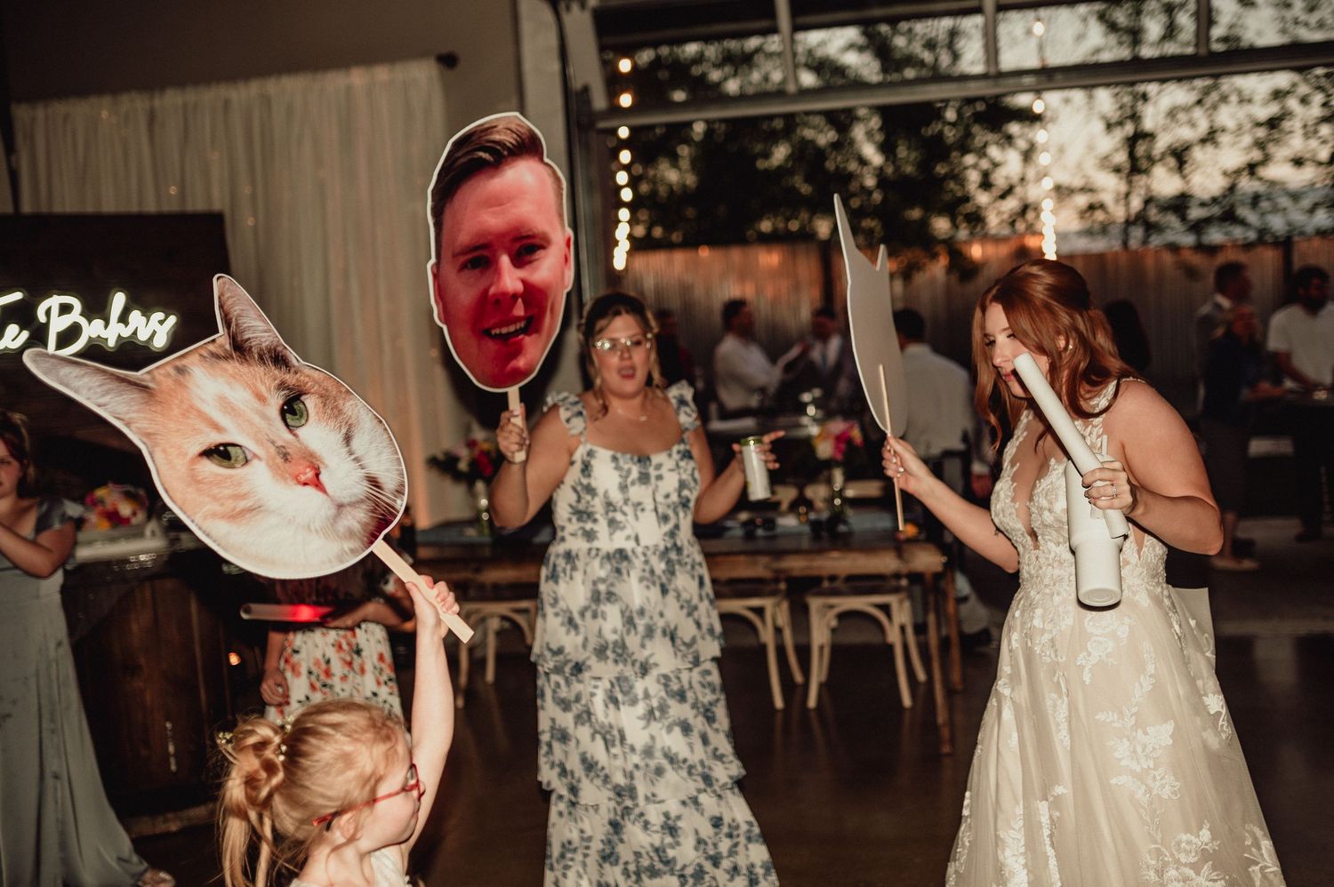Wedding guests dance and celebrate on a dimly lit dance floor during an evening reception party.