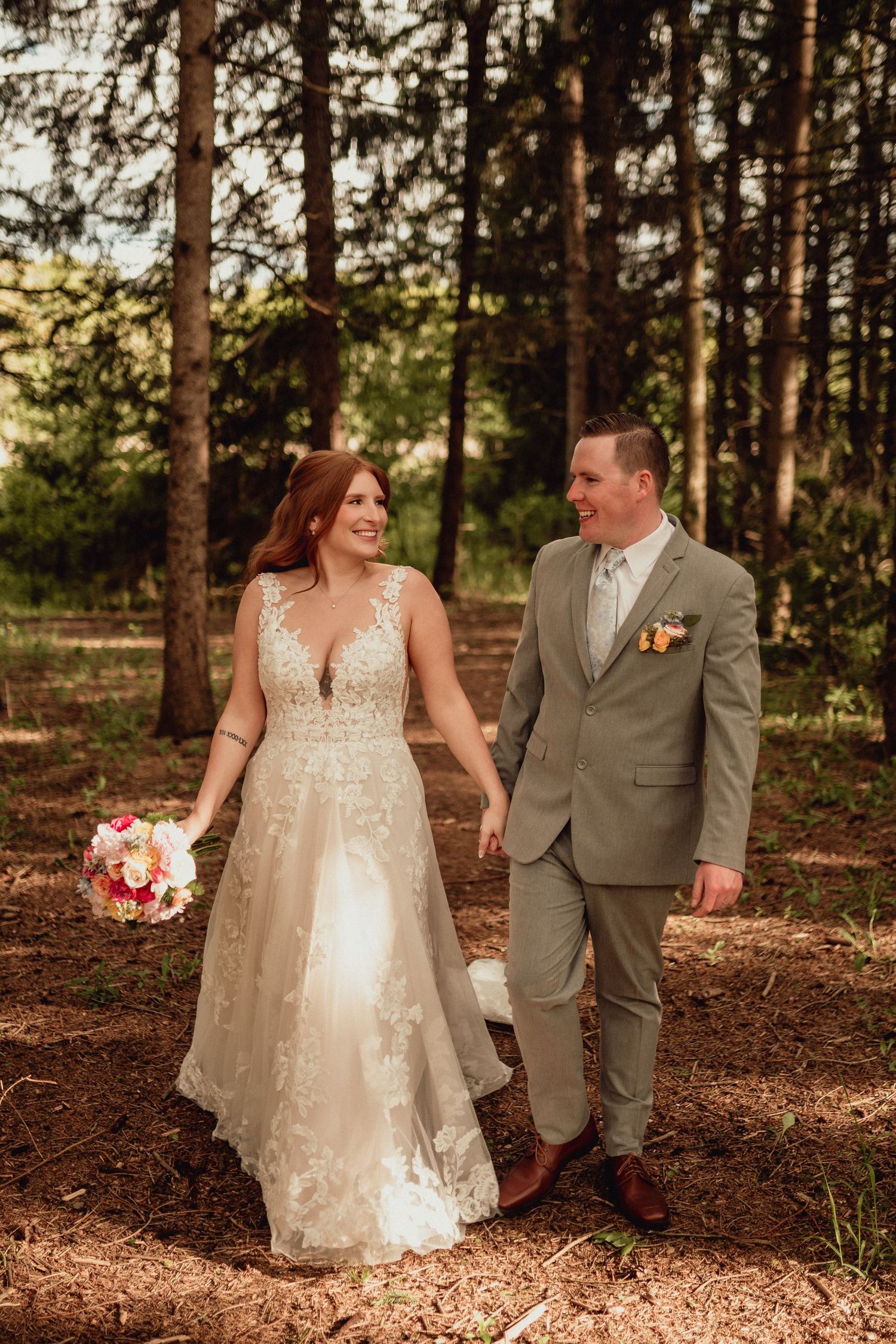 A couple shares romantic moments in a pine forest setting during their wedding celebration.