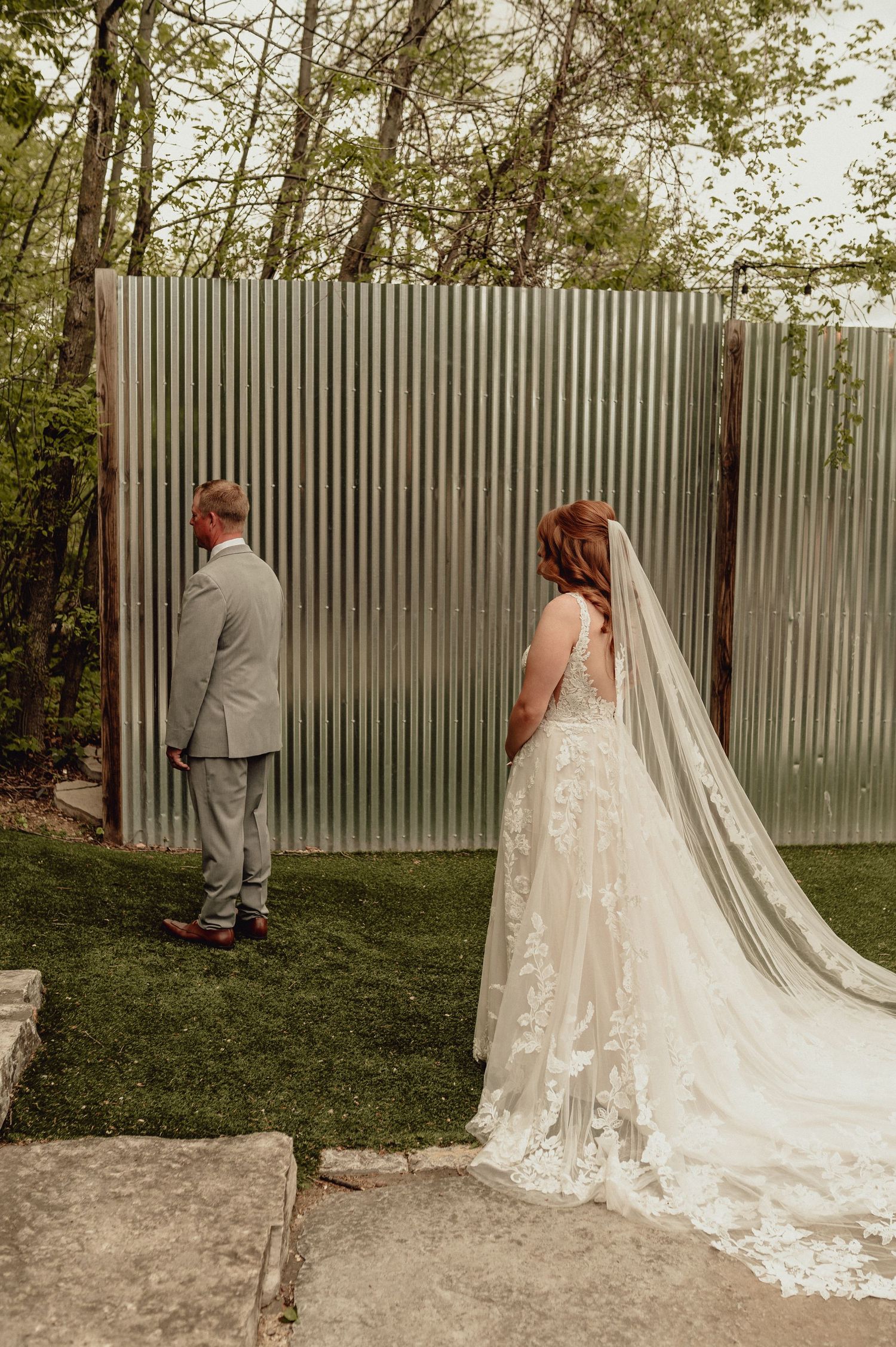 A sequence of wedding photos shows a couple having their first look moment behind a corrugated metal wall outdoors.