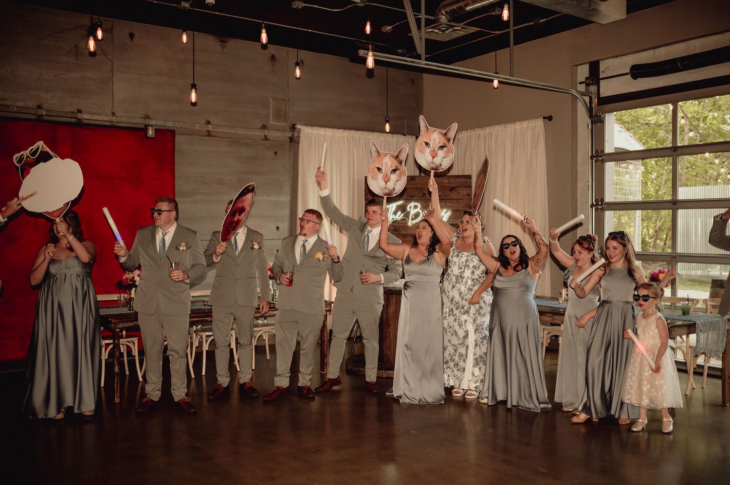 Wedding party dances and celebrates on a wooden dance floor during reception festivities.