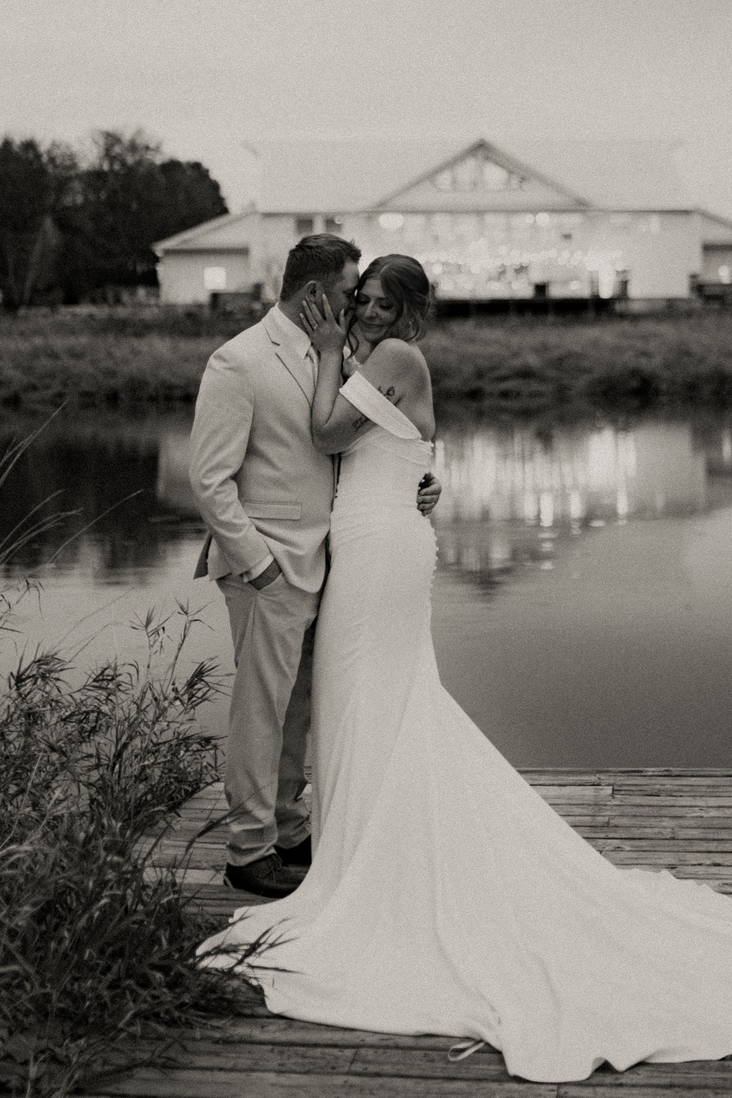 Black and white photo series of a romantic lakeside wedding moment with a couple in formal attire by the water.
