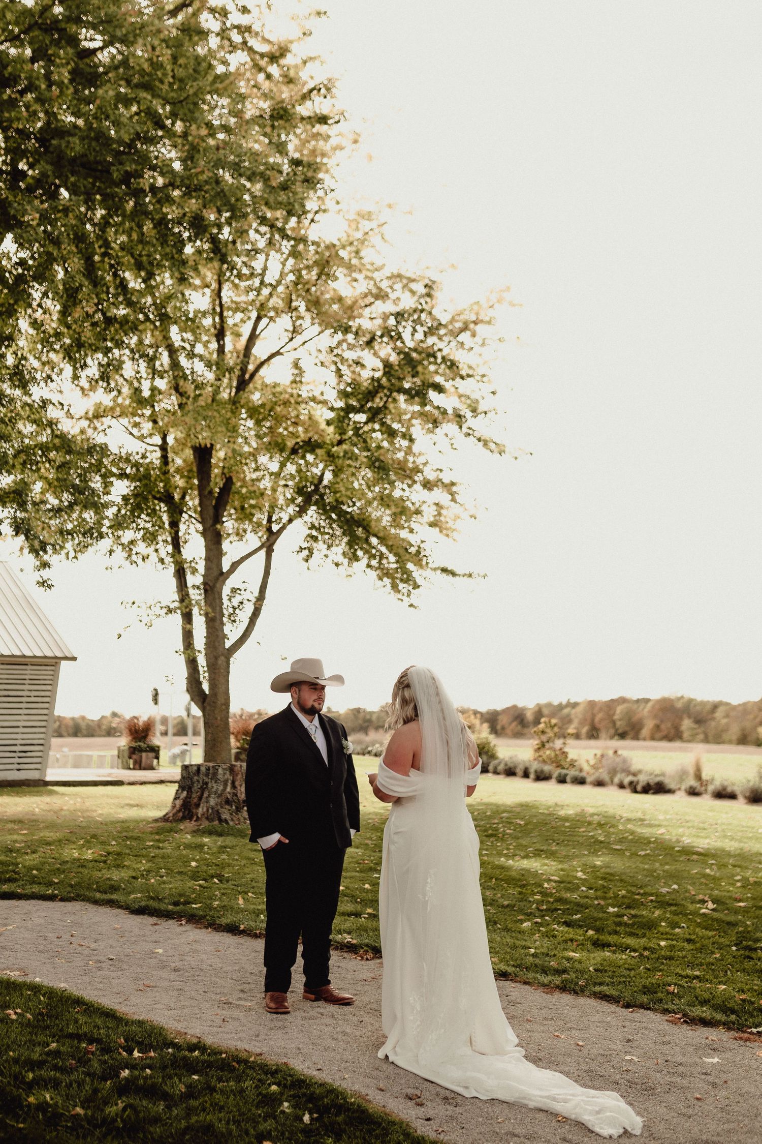 A couple shares their first look moment in an outdoor garden setting on their wedding day.