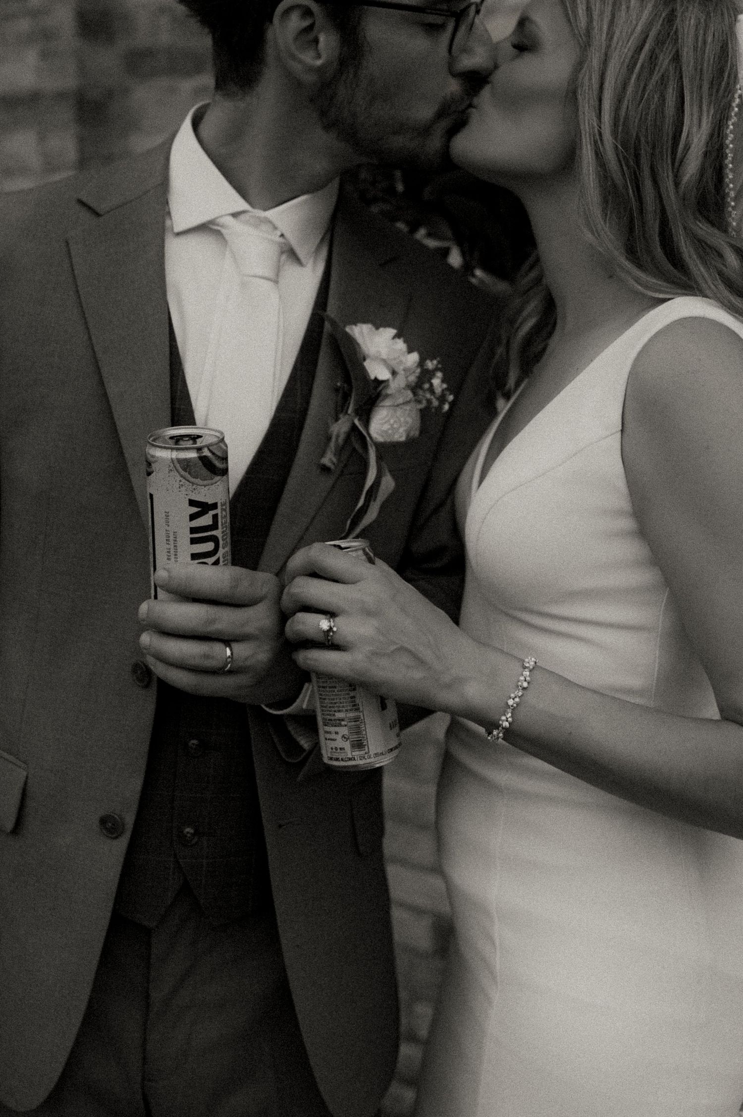 Wedding couple shares drinks in an intimate black and white candid moment.