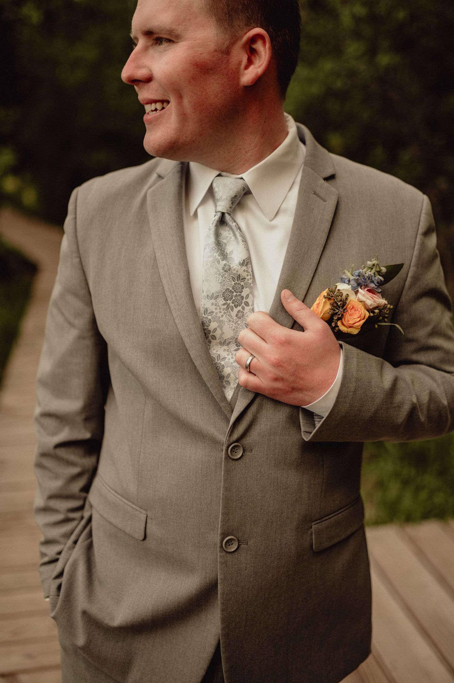 Close-up shots of a groom in a gray suit with orange boutonniere showing different angles and details of the wedding attire.