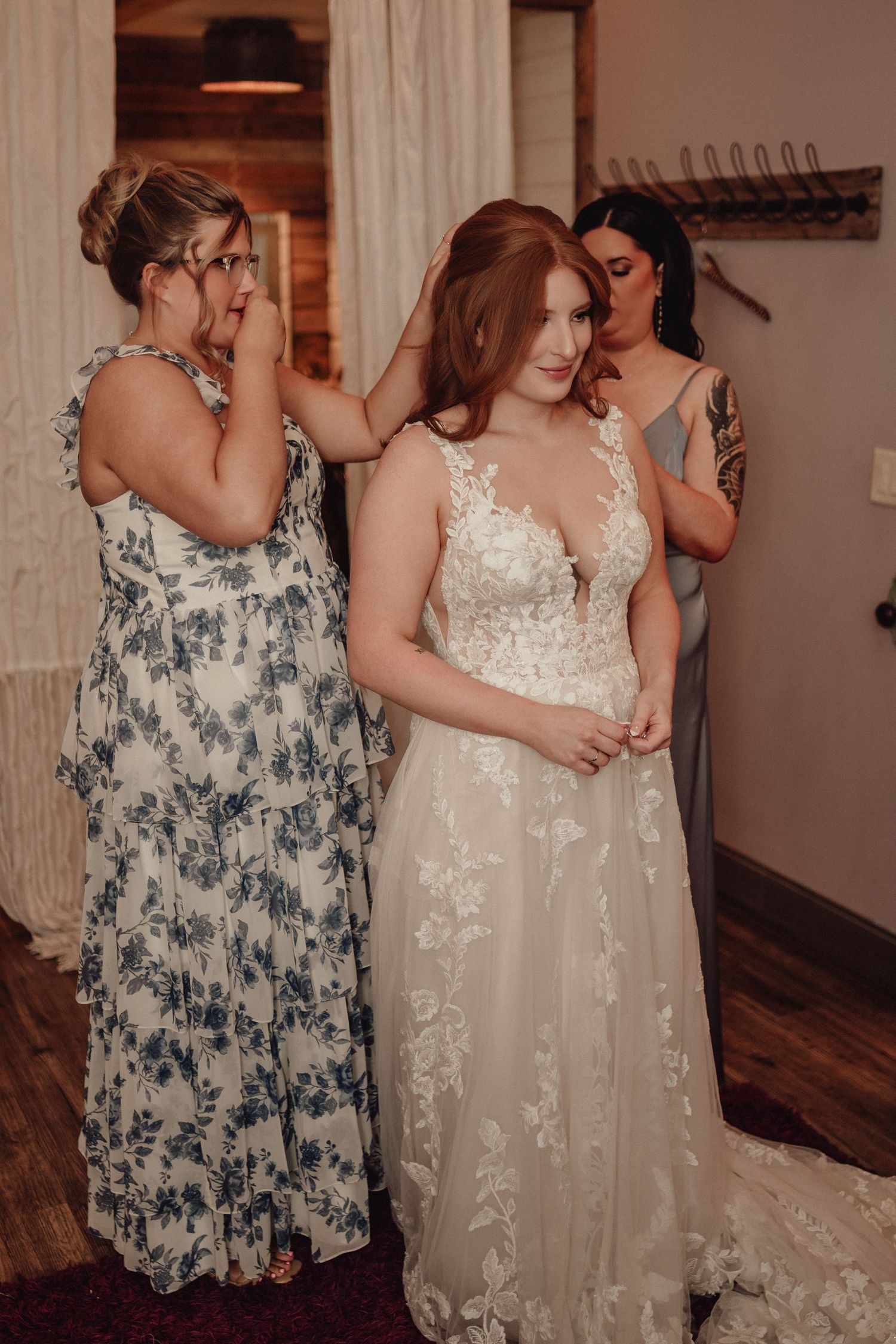 Two figures embrace in a tender moment, with one wearing a detailed white lace wedding gown.