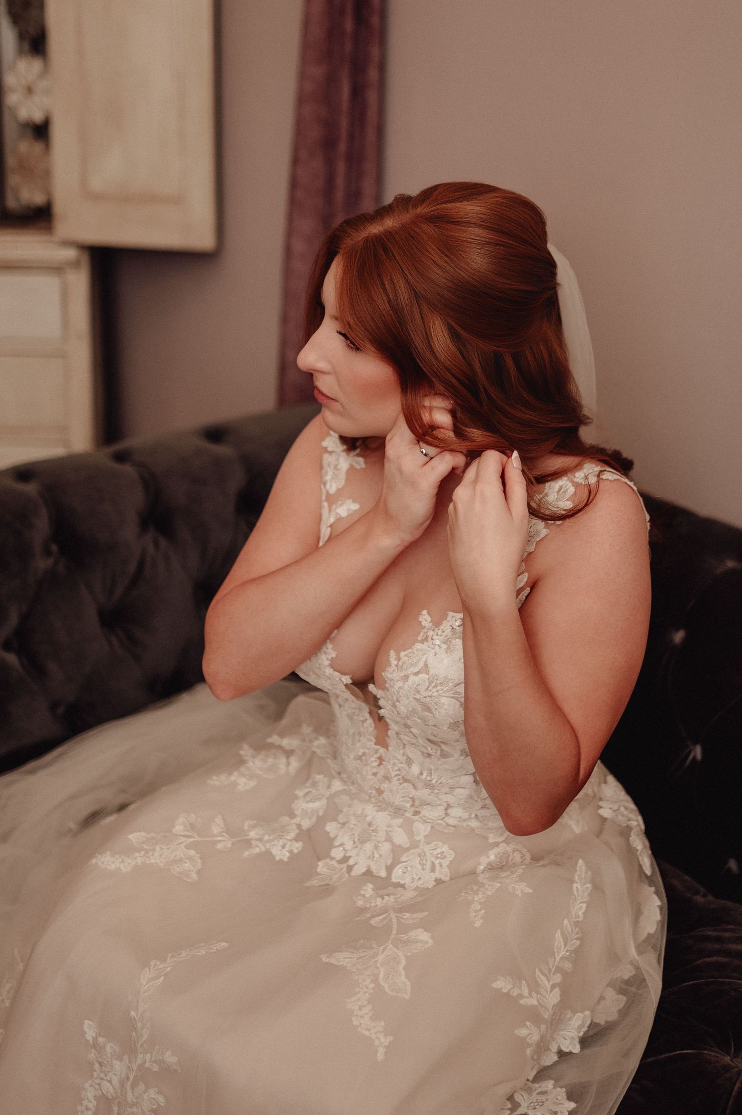 A bride in a white lace wedding dress sits on a dark couch in a series of emotional candid moments.